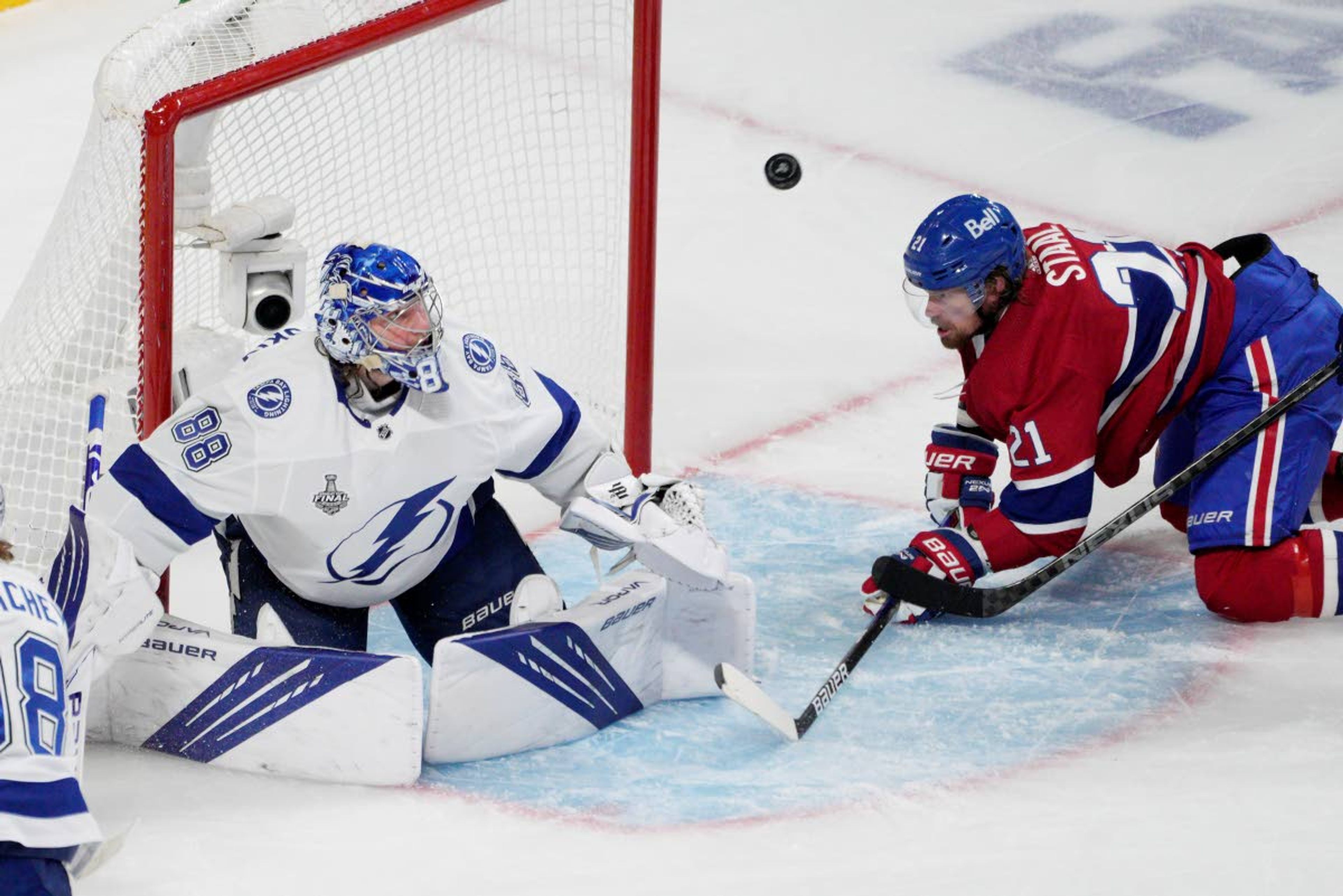 Tampa Bay Lightning goaltender Andrei Vasilevskiy (88) looks at the puck after making a save against Montreal Canadiens center Eric Staal (21) during the second period of Game 4 of the NHL hockey Stanley Cup final in Montreal, Monday, July 5, 2021. (Paul Chiasson/The Canadian Press via AP)