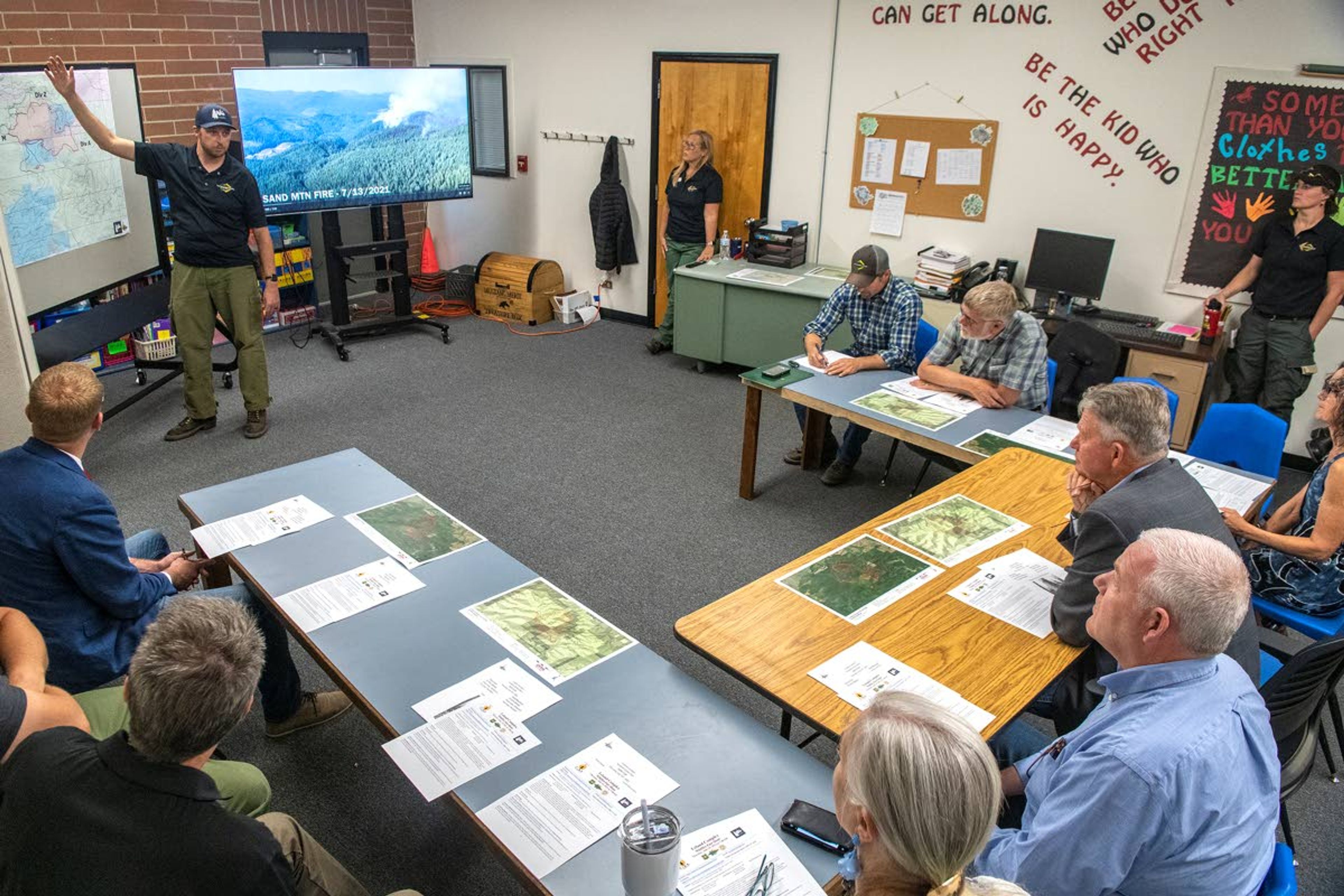 Incident Command Mike McManus, of the Type 3 North Idaho Incident Management team, briefs a collection of people including Idaho Gov. Brad Little on the crew’s ongoing wildfire battle against the Sand Mountain Fire and Pine Creek Fire at Deary High School on Thursday morning.