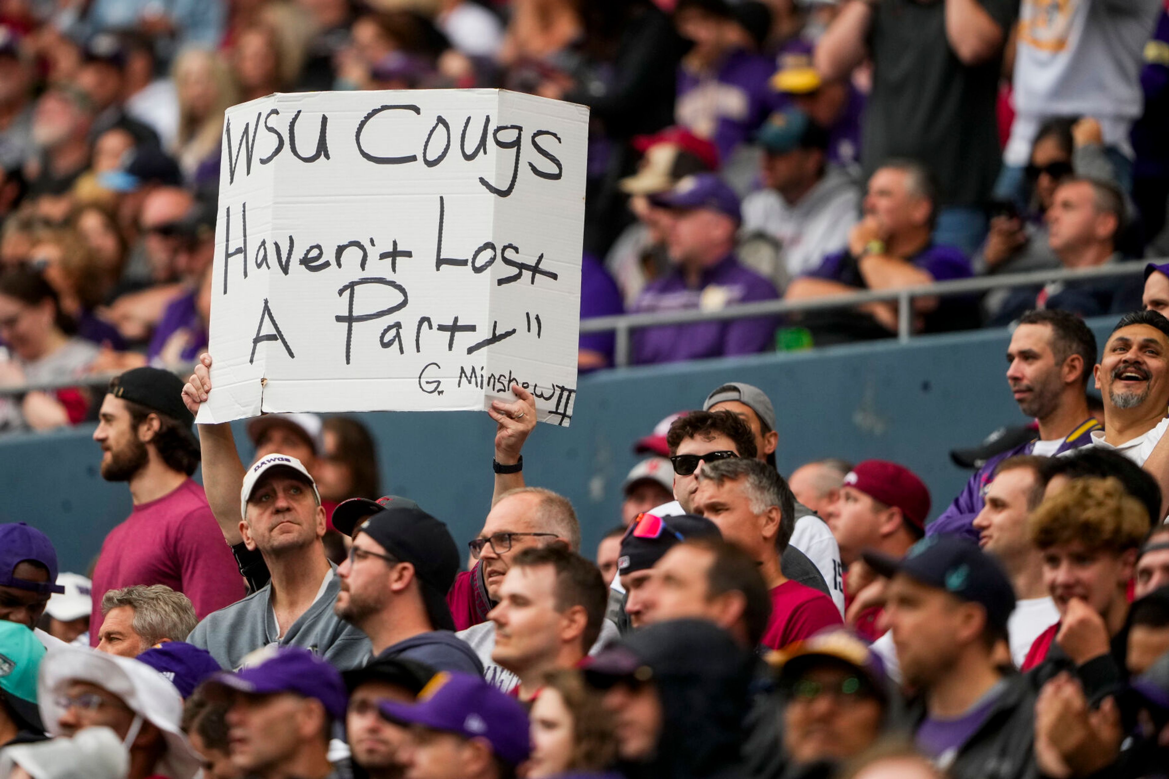 A Washington State fan holds up a sign during the second half of an NCAA college football game against Washington, Saturday, Sept. 14, 2024, in Seattle. Washington State won 24-19. (AP Photo/Lindsey Wasson)