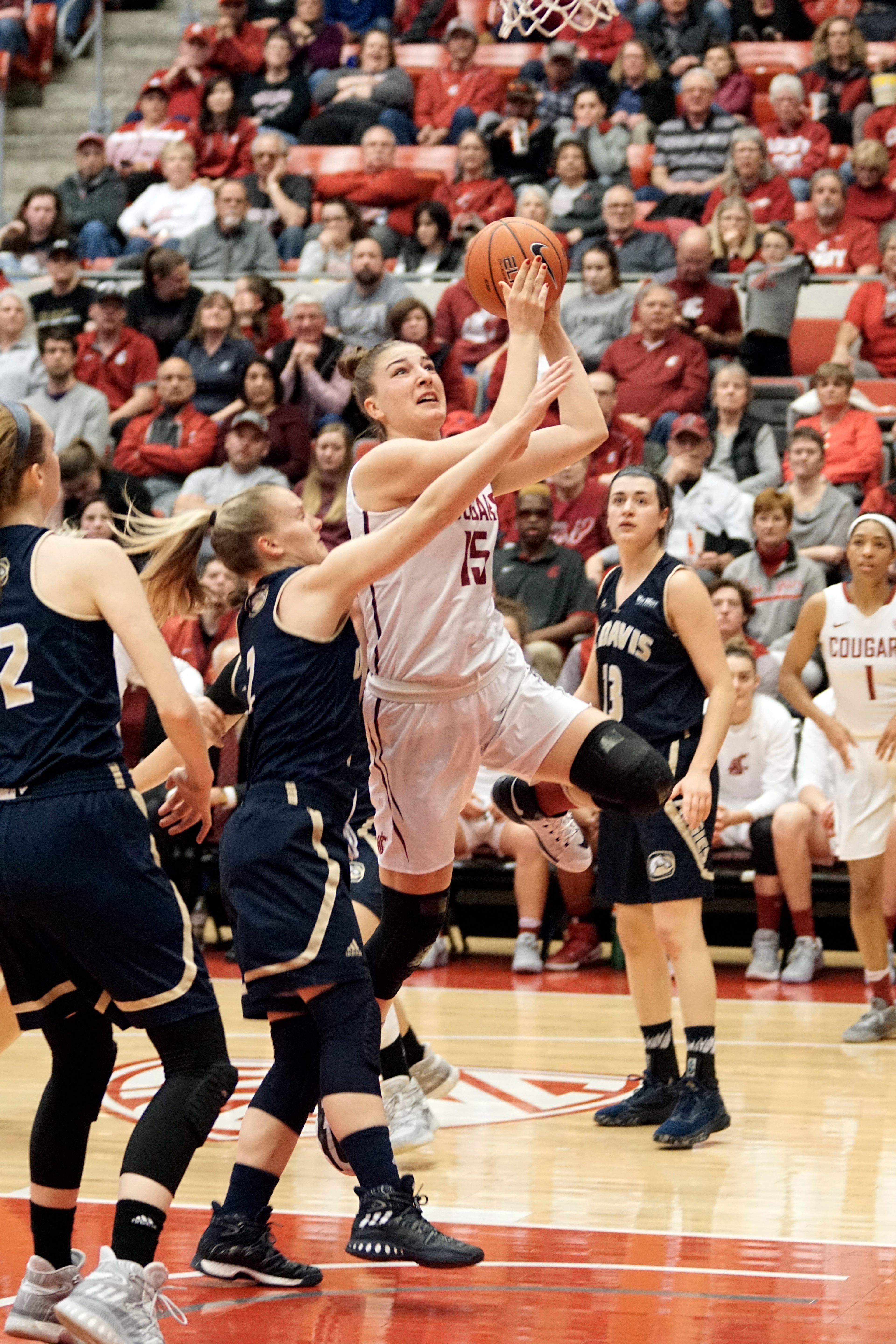 Washington State senior forward Ivana Kmetovska (15) leaps past UC Davis guard Kourtney Eaton during a third round game of the WNIT at Beasely Coliseum Thursday night.