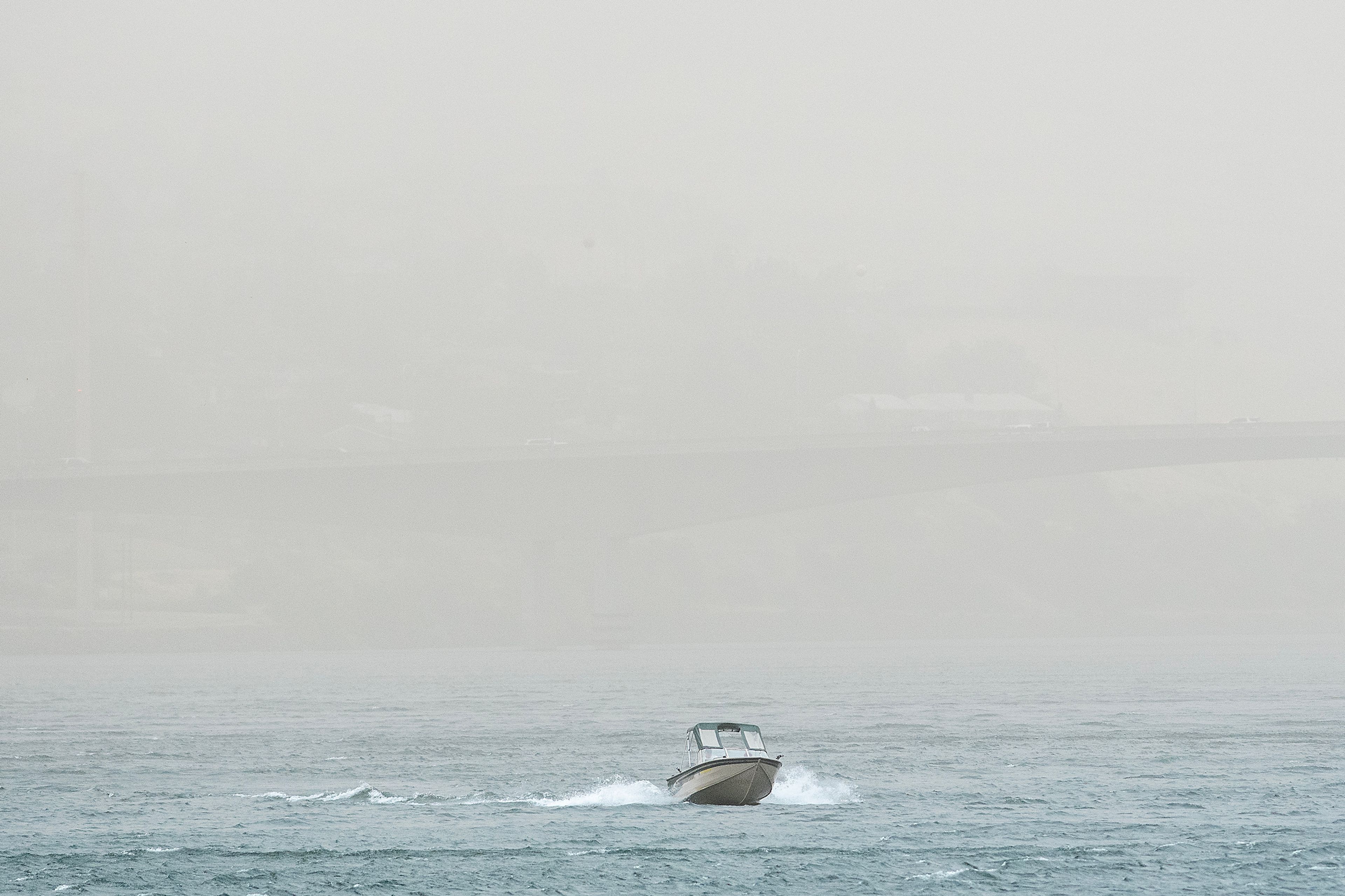 A boat moves through the Snake River as dust from heavy wind obscures the view Friday in the Lewiston-Clarkston Valley.