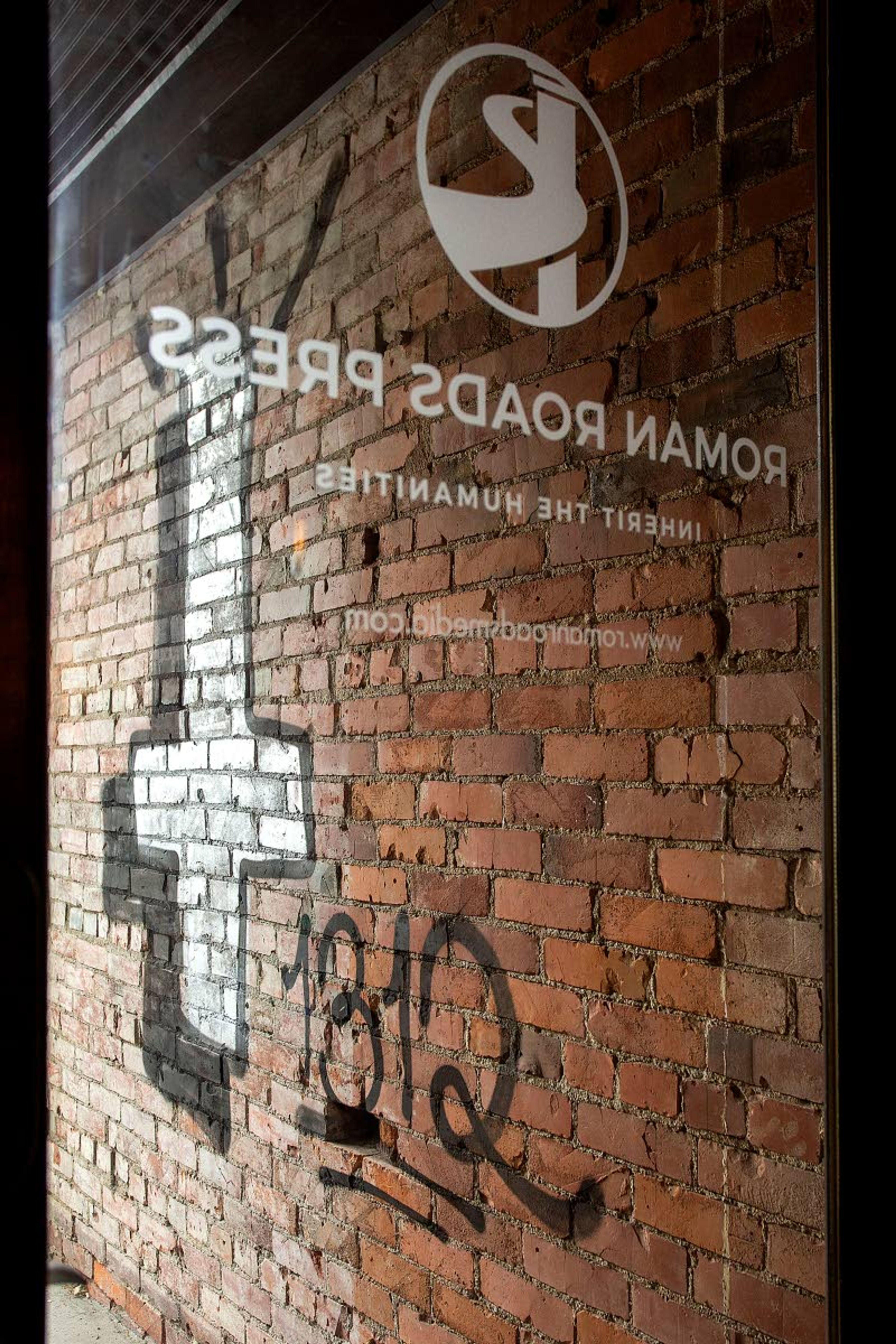 Graffiti, including an inverted cross and the number "1312", is seen outside Roman Roads Press on Monday on East Third Street in Moscow. Graffiti was also painted on the wall of Canon Press on North Main Street.