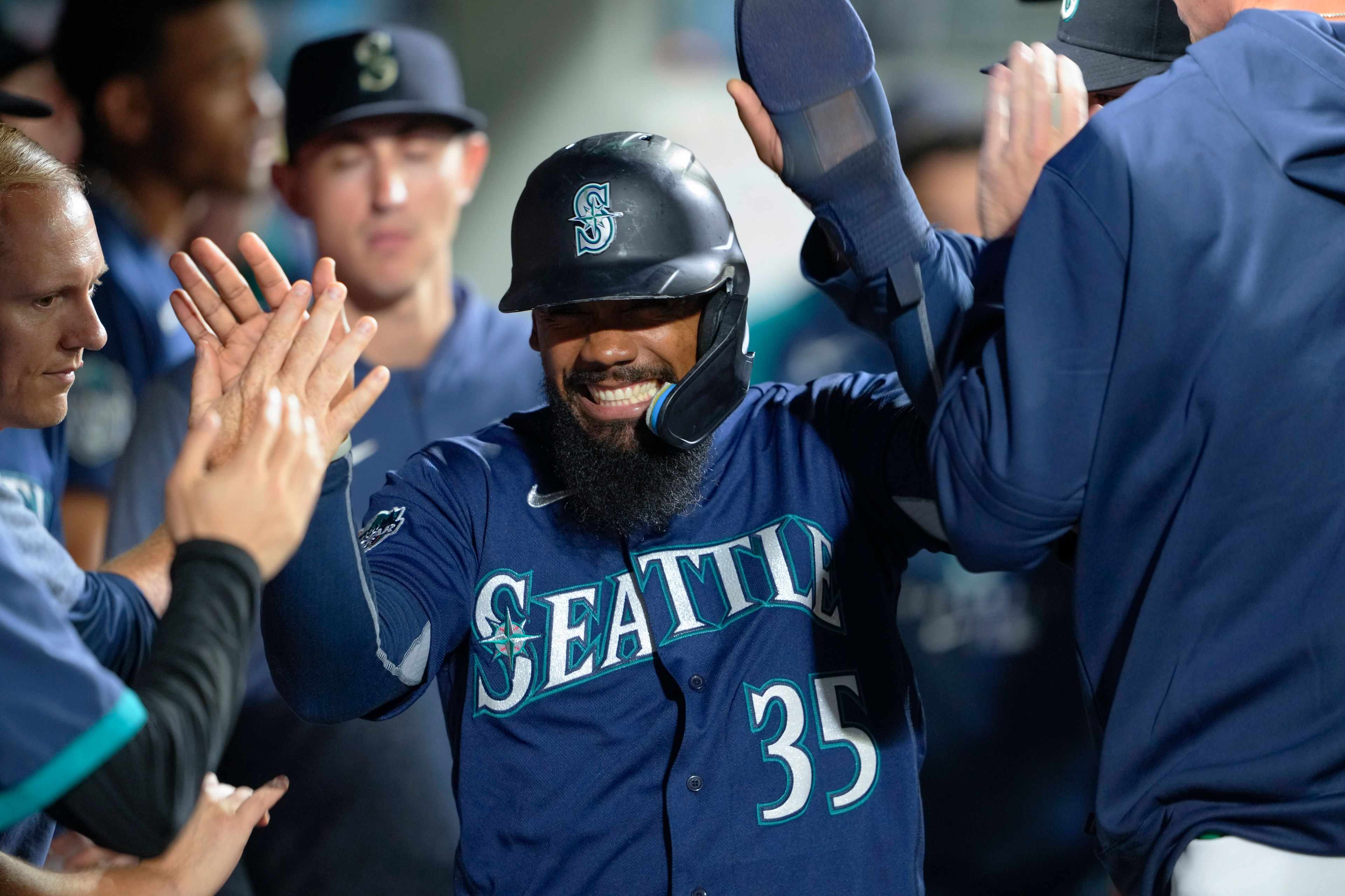 The Mariners' Teoscar Hernandez is greeted in the dugout after scoring on a double by Ty France against the Padres during the eighth inning of a game Wednesday in Seattle.