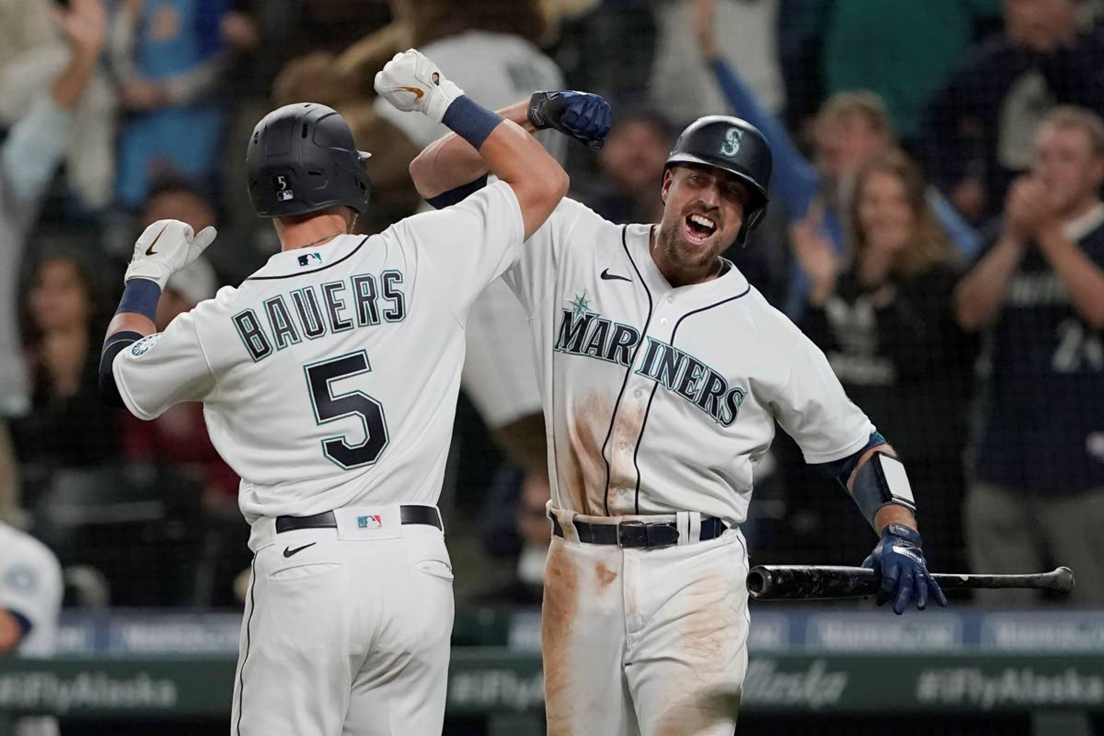 Seattle Mariners' Jake Bauers (5) is greeted by Tom Murphy after Bauers hit a go-ahead solo home run against the Minnesota Twins during the eighth inning of a baseball game, Monday, June 14, 2021, in Seattle. The Mariners won 4-3. (AP Photo/Ted S. Warren)