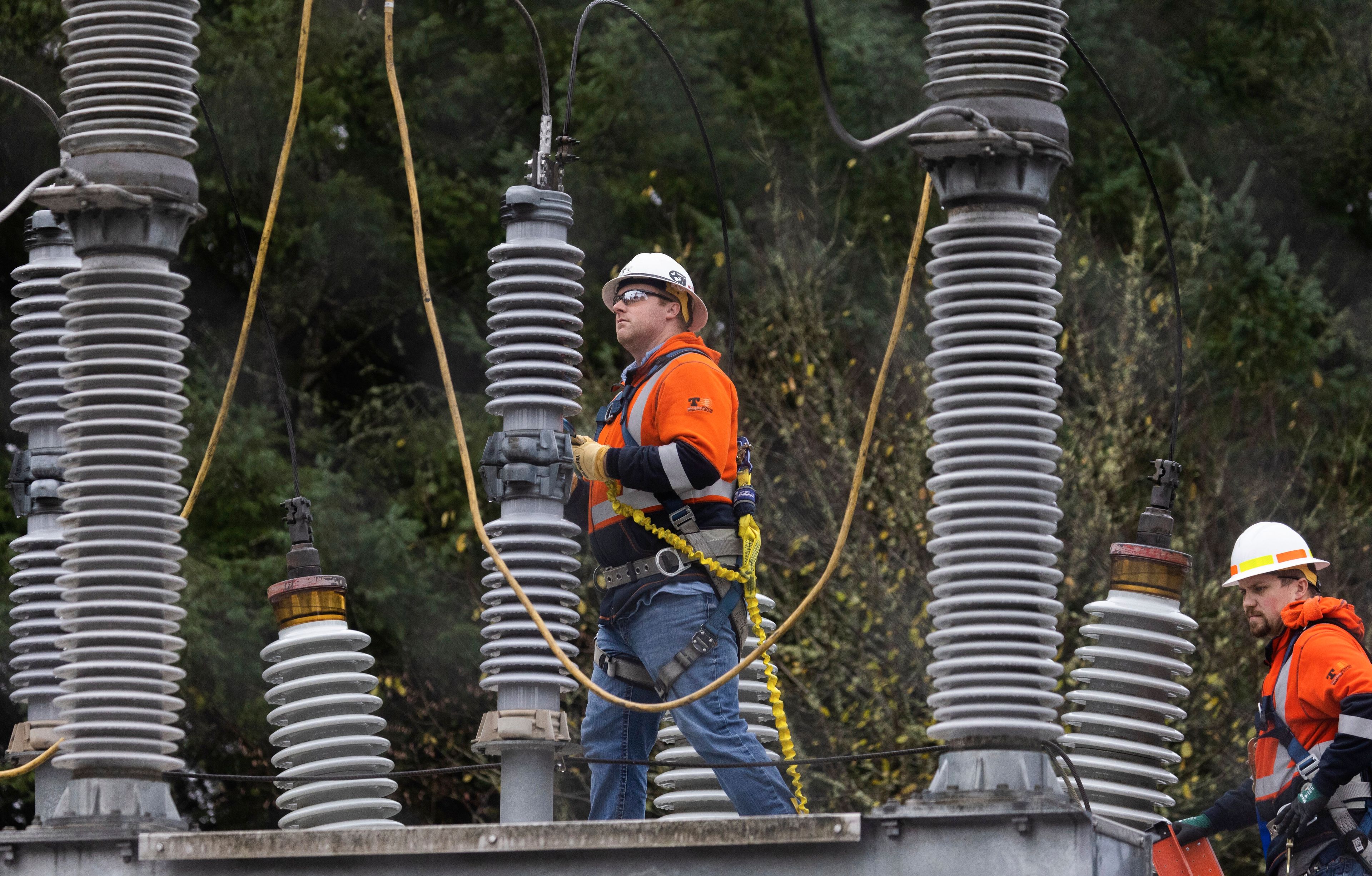 A Tacoma Power crew works at an electrical substation damaged by vandals early on Christmas morning, Sunday, Dec. 25, 2022, in Graham, Wa. (Ken Lambert/The Seattle Times via AP)