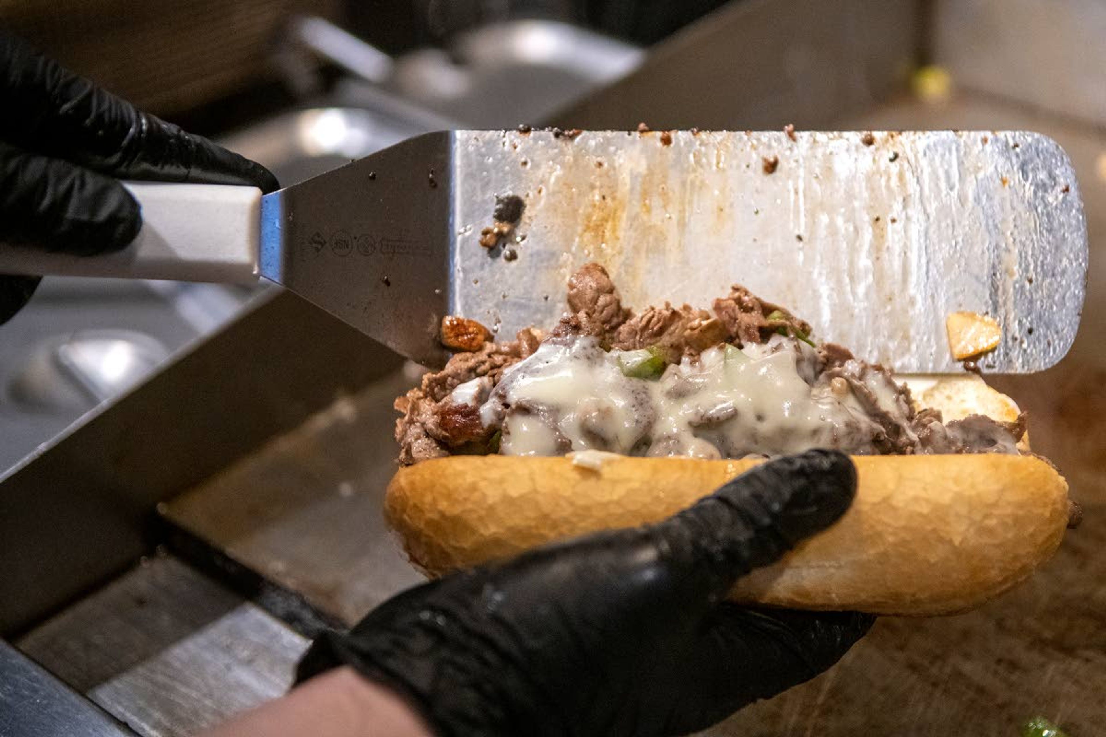 Timber Bar and Grill cook Trenton Bolen makes a “The Stubblefield” sandwich Wednesday afternoon at Lumberyard in Pullman.