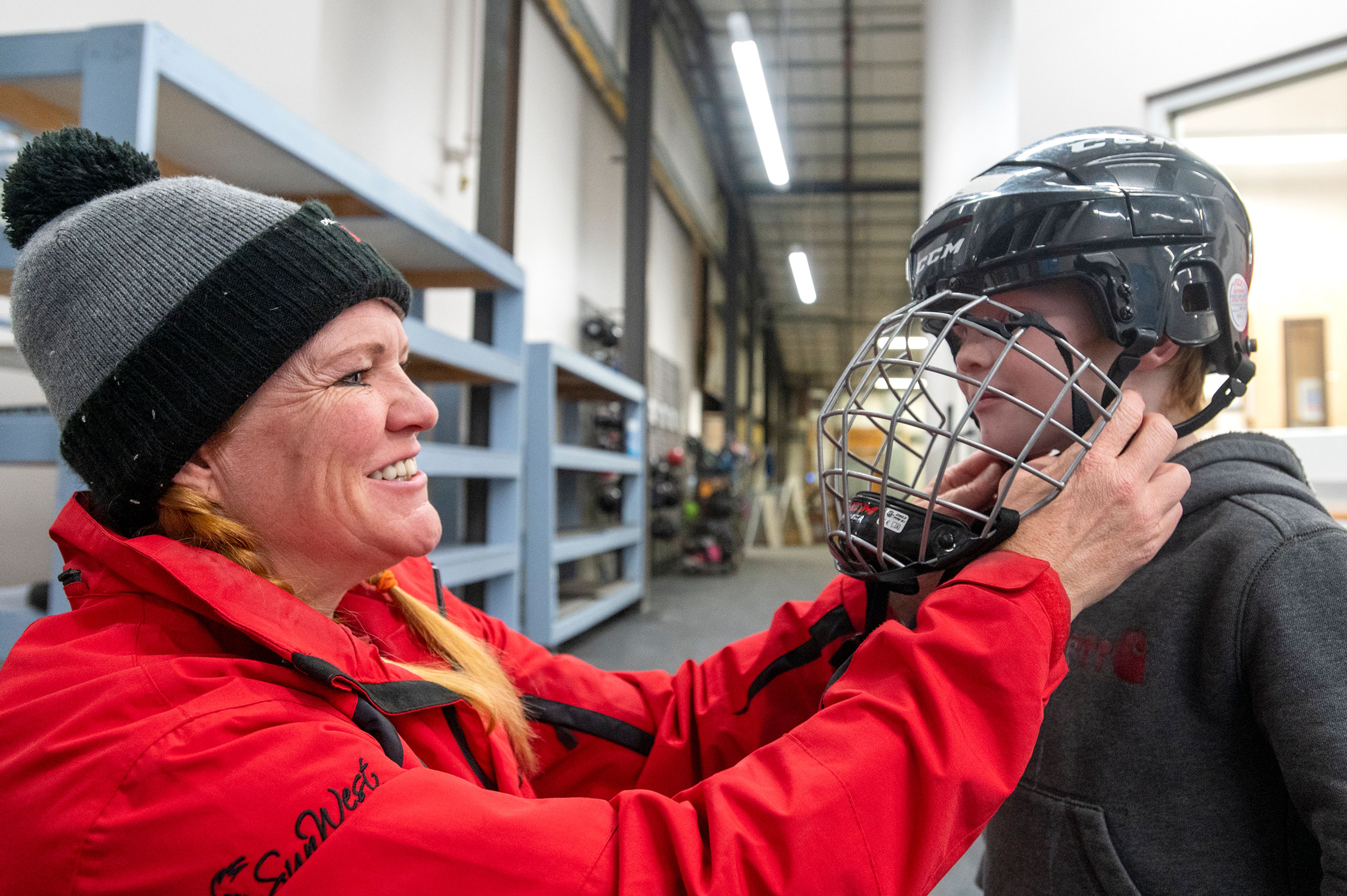 Julie Schott helps her son, Blaze, 5, put on his hockey helmet before skating on the new Palouse Ice Rink during opening night in Moscow on Monday.