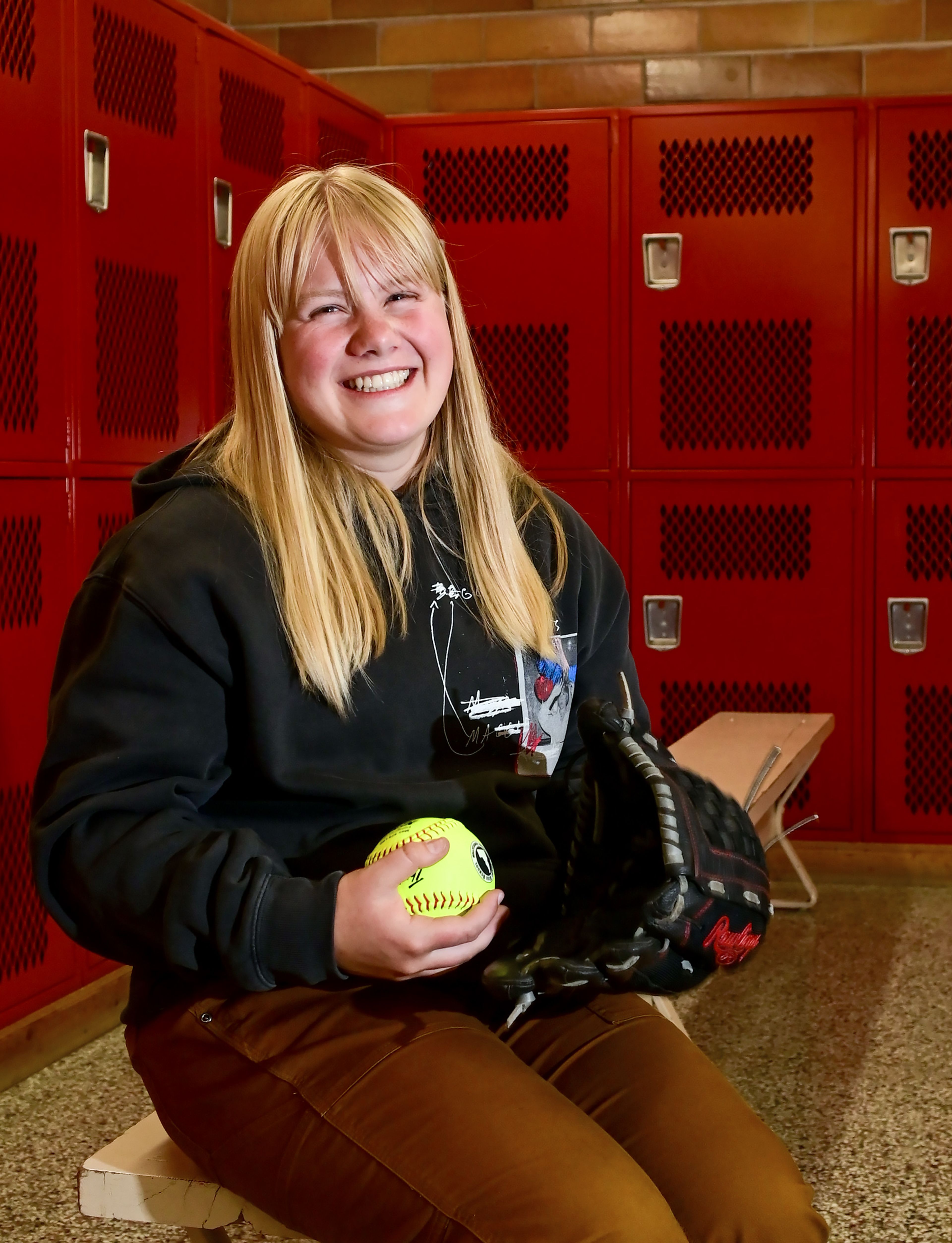 Graduating Moscow High School senior Addison Branen poses with her glove and a softball in the school’s locker room on Tuesday. Branen is a 4.0 student who is signed to play college softball.