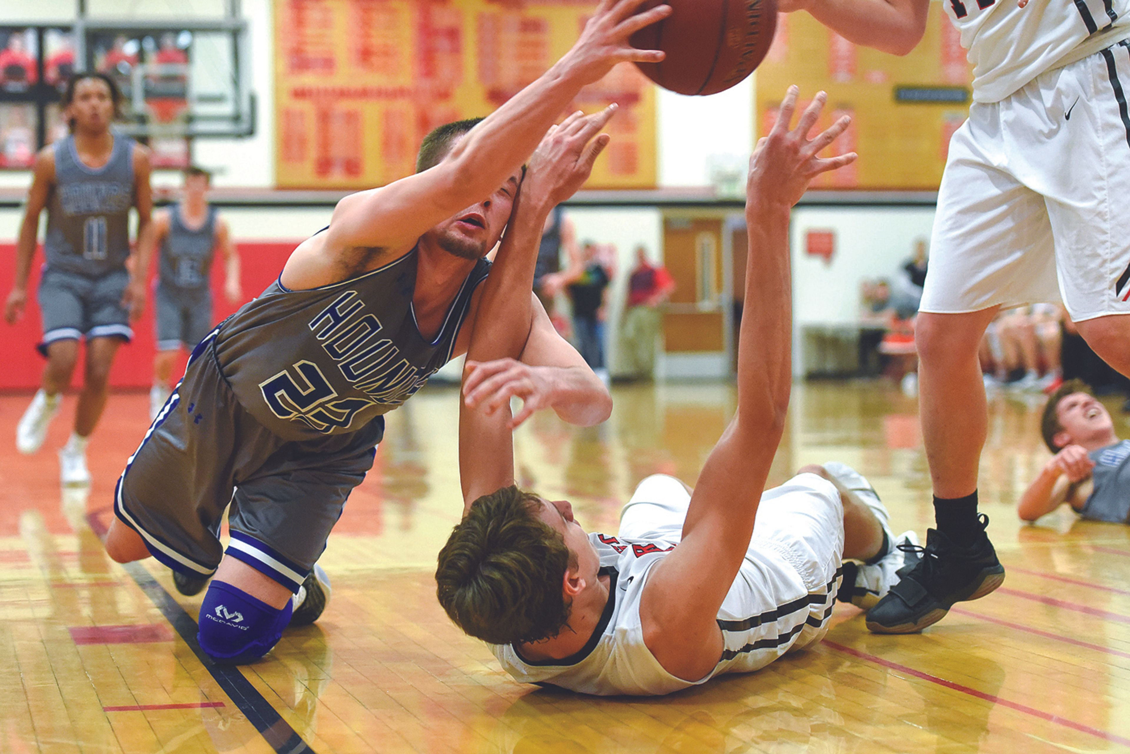 Pullman's Jake Wells knocks the ball away from Clarkston's Brandton Chatfield during a scramble underneath the basket during the third quarter of a Great Northern League basketball game in Clarkston on Wednesday.