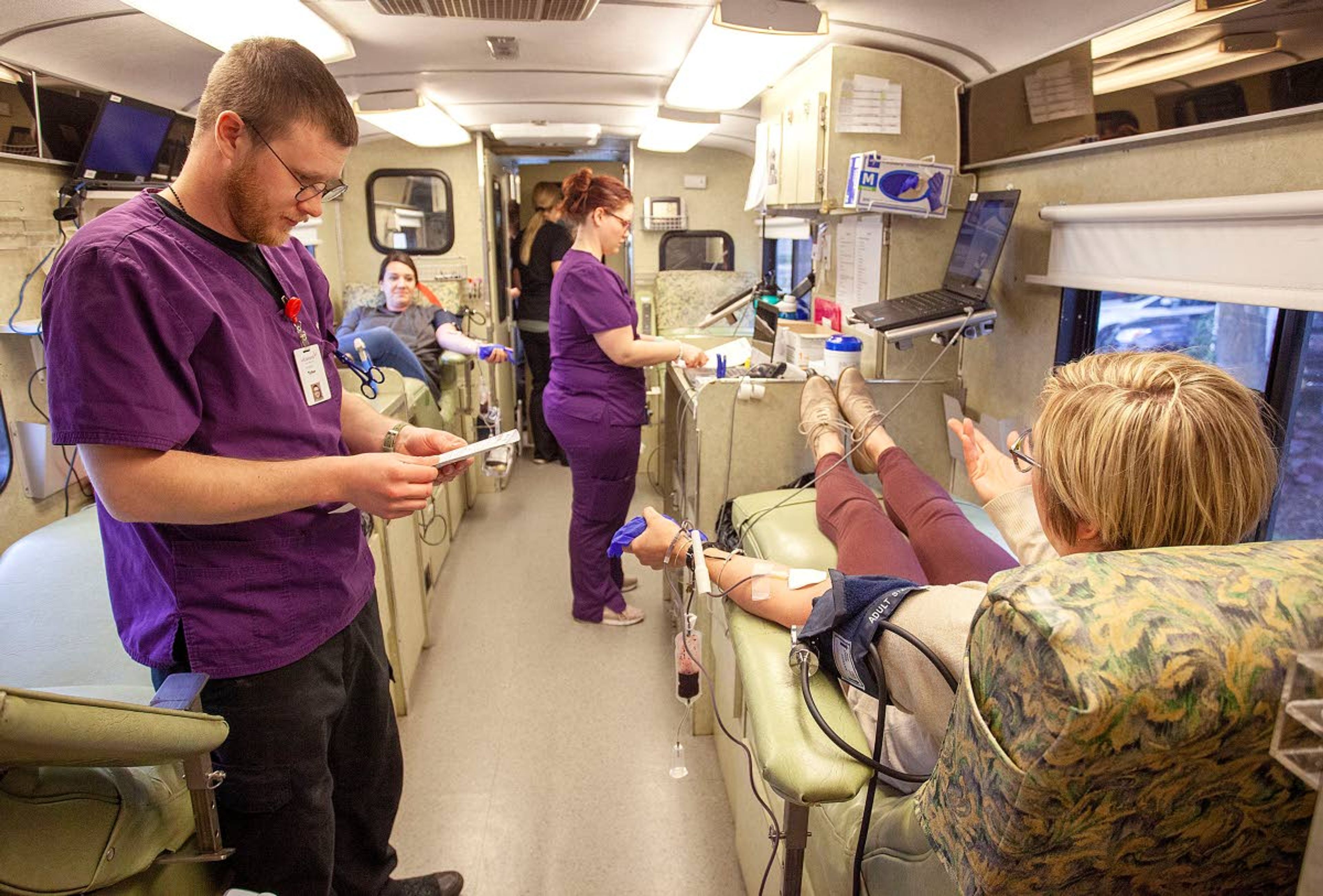 Phlebotomists Tyler Covey, left, and Cori Keeler help city of Pullman employees Megan Vining, right, and Cristin Reisenaur donate blood during a blood drive Wednesday outside Pullman City Hall. Vitalant is encouraging people to donate blood because some regular donors are staying home because they are concerned about the COVID-19 virus.