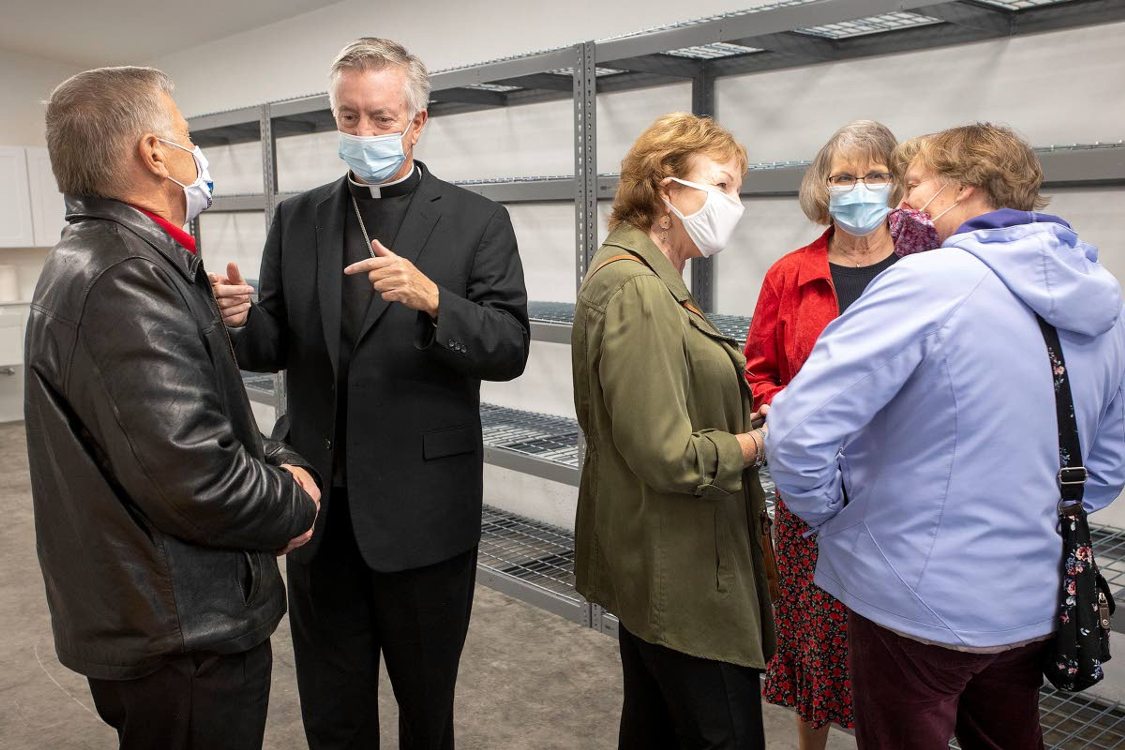 Christensen (second from left), talks with Moscow Mayor Bill Lambert (left), while Moscow Food Bank Director Linda Nickels (second from right) talks with other guests after the ribbon-cutting and blessing of a new building at the food bank on Saturday.