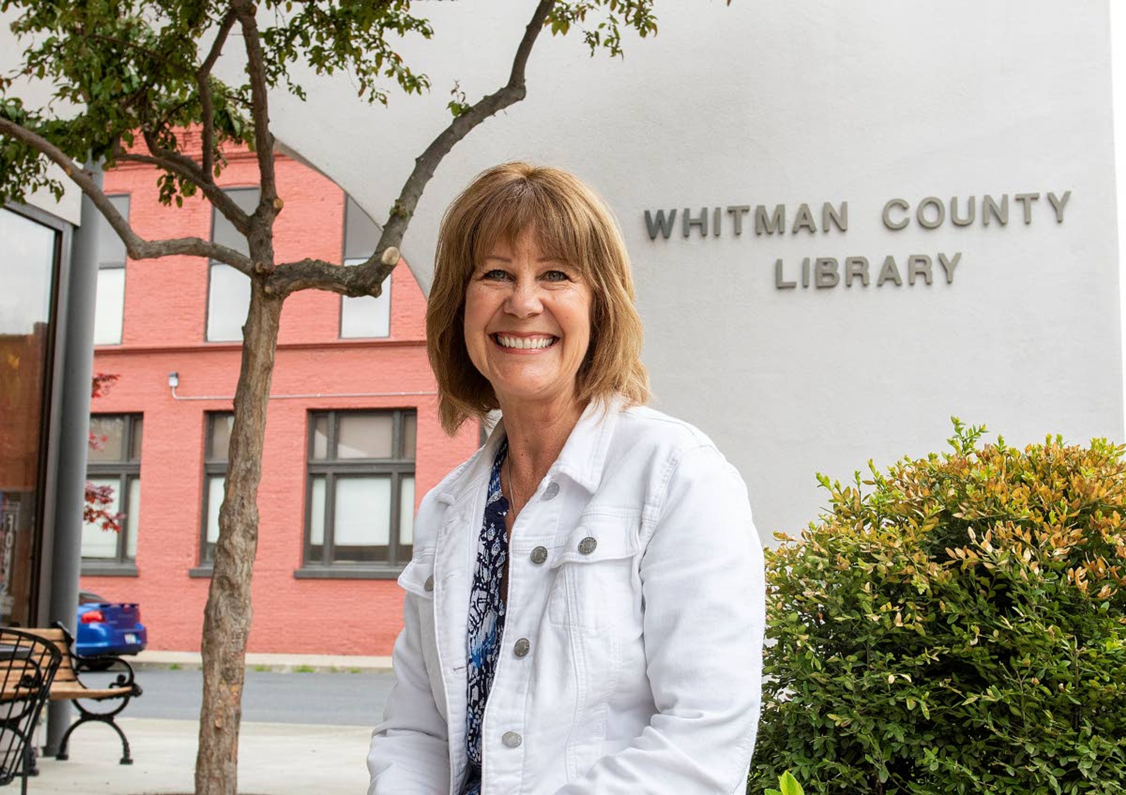 Whitman County Rural Library District Director Kristie Kirkpatrick sits outside the library in Colfax. The library district is celebrating its 75th anniversary this year. Kirkpatrick is planning to retire in October, after working for the library district since 1988.