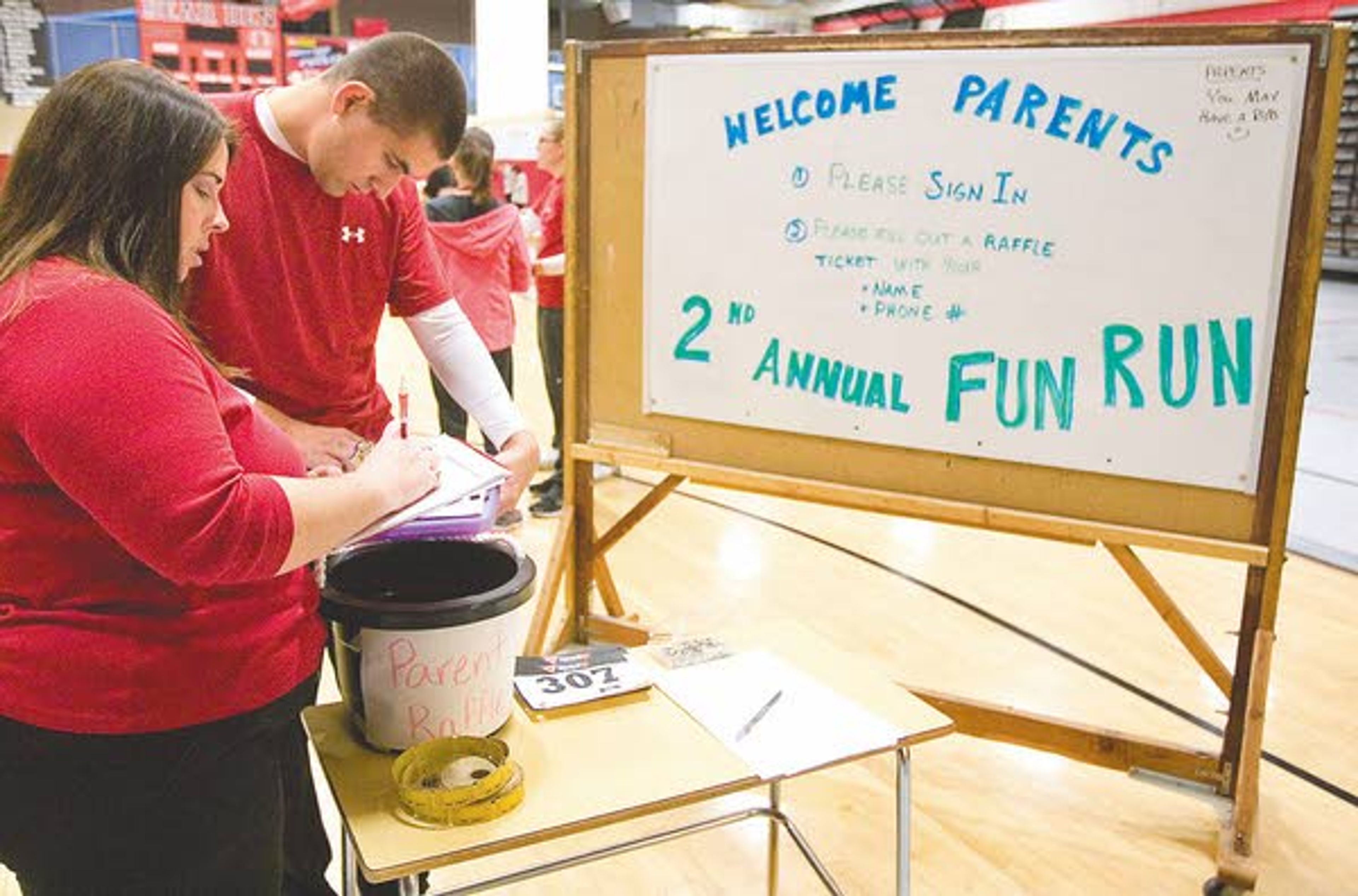 Teacher Jennifer Lynn, left, and student teacher Nick Hazeltine check class roles before seventh-grade students run in a fun run at Moscow Middle School on Monday.