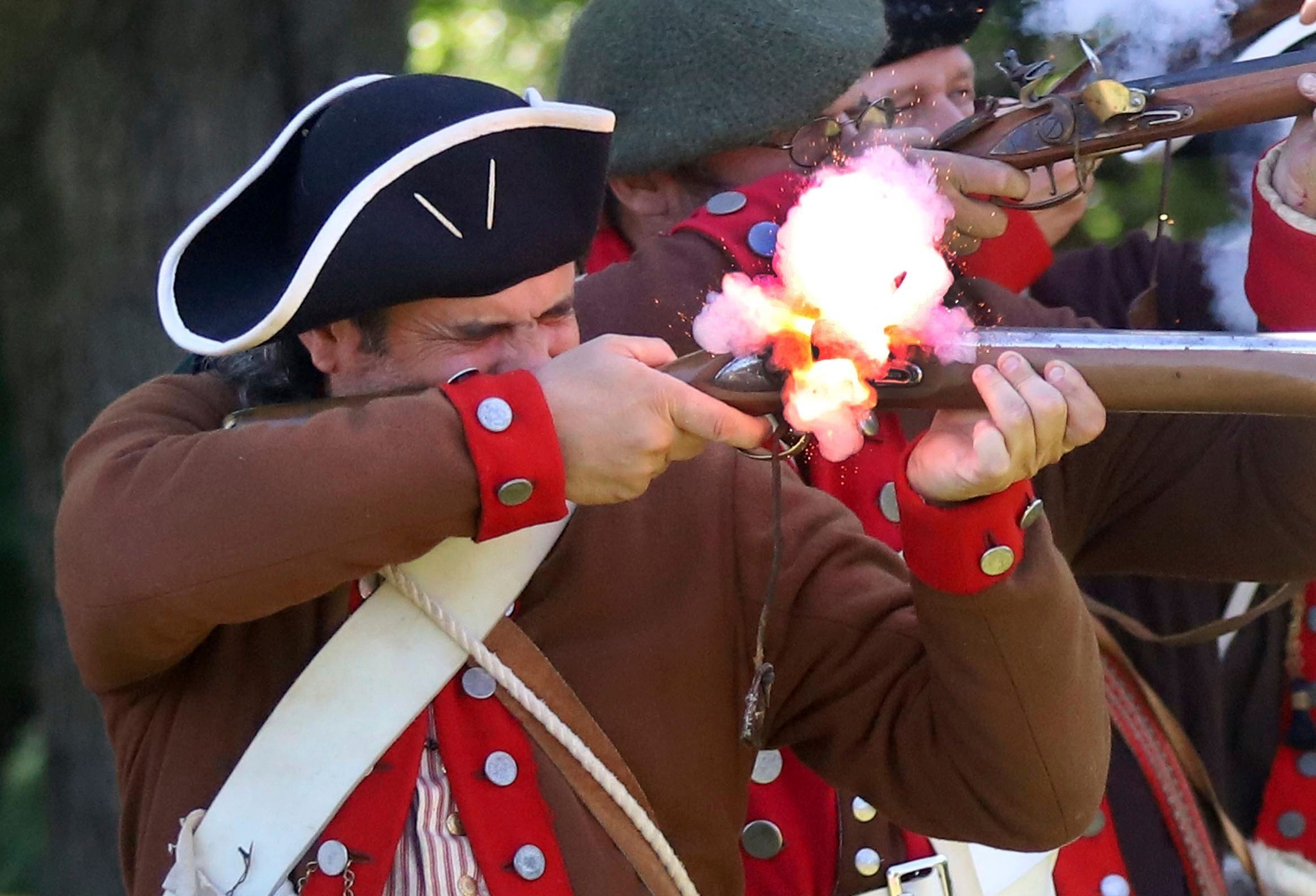 Matt Lyons, a member of the 24th Connecticut Militia, fires his musket during the 144th annual Commemorative Service for the Battle and Massacre of Wyoming held on the grounds of the Wyoming Monument Monday July 4, 2022, in Wyoming Pa. (Dave Scherbenco/The Citizens' Voice via AP)