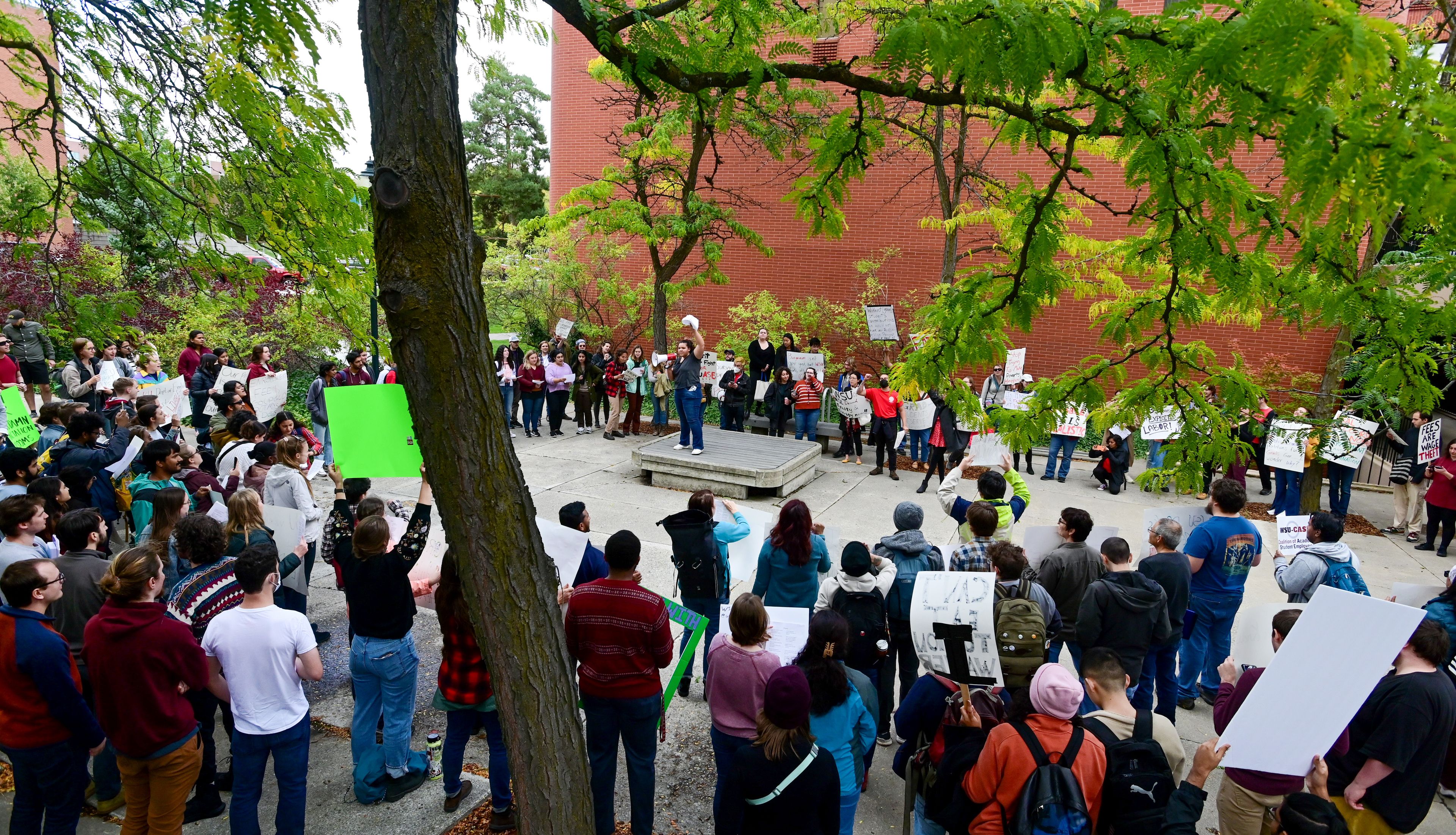 Sierra Forler, center, a second-year PhD student in biological sciences at Washington State University, leads those gathered for a rally supporting contract negotiations for Academic Student Employees in a series of chants in front of the French Administration Building on Wednesday in Pullman. The group marched down Glenn Terrell Mall after listening to a series of speakers.