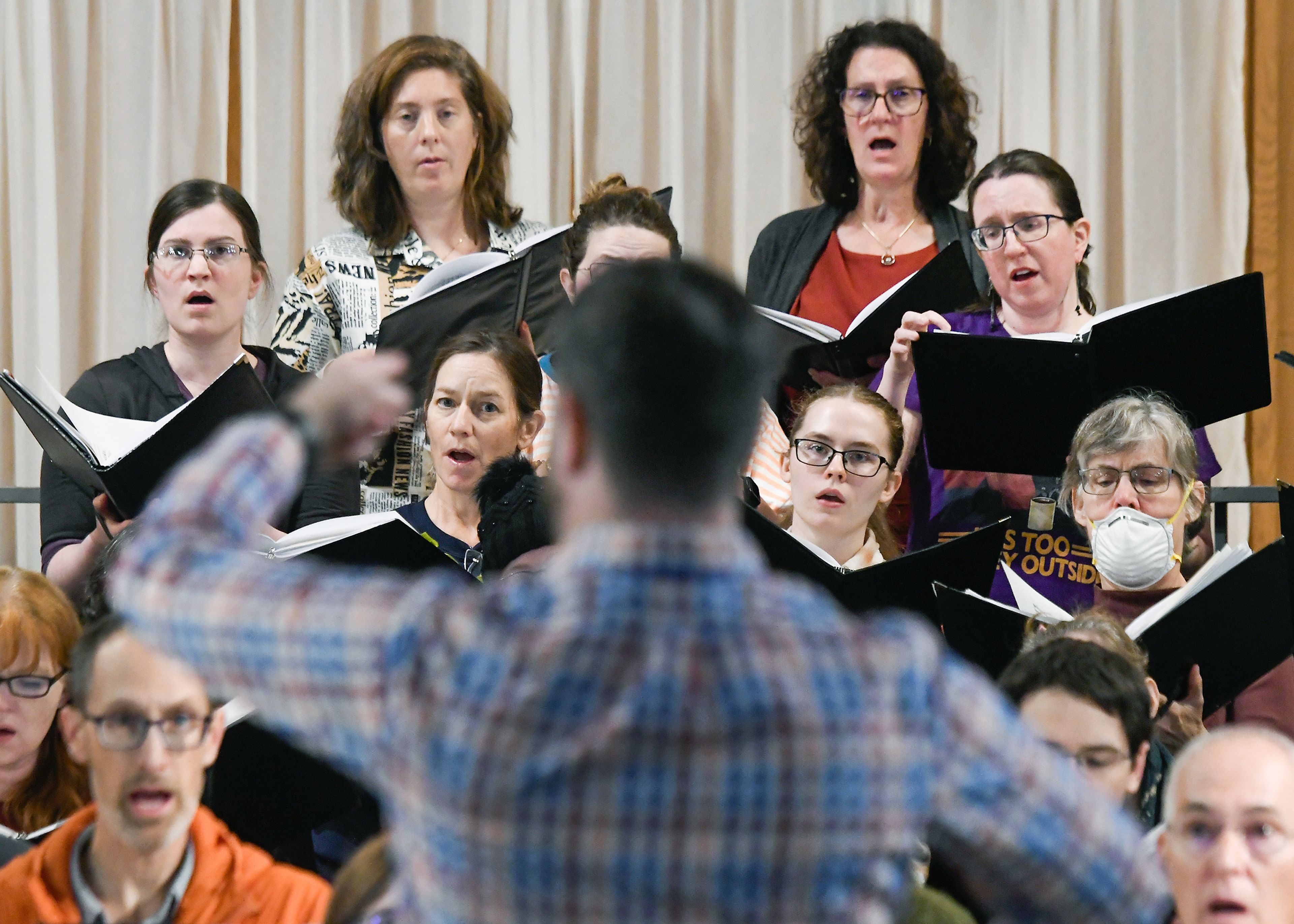 Members of the Palouse Choral Society follow the conducting of artistic director Matthew Myers in a rehearsal Monday in Pullman.