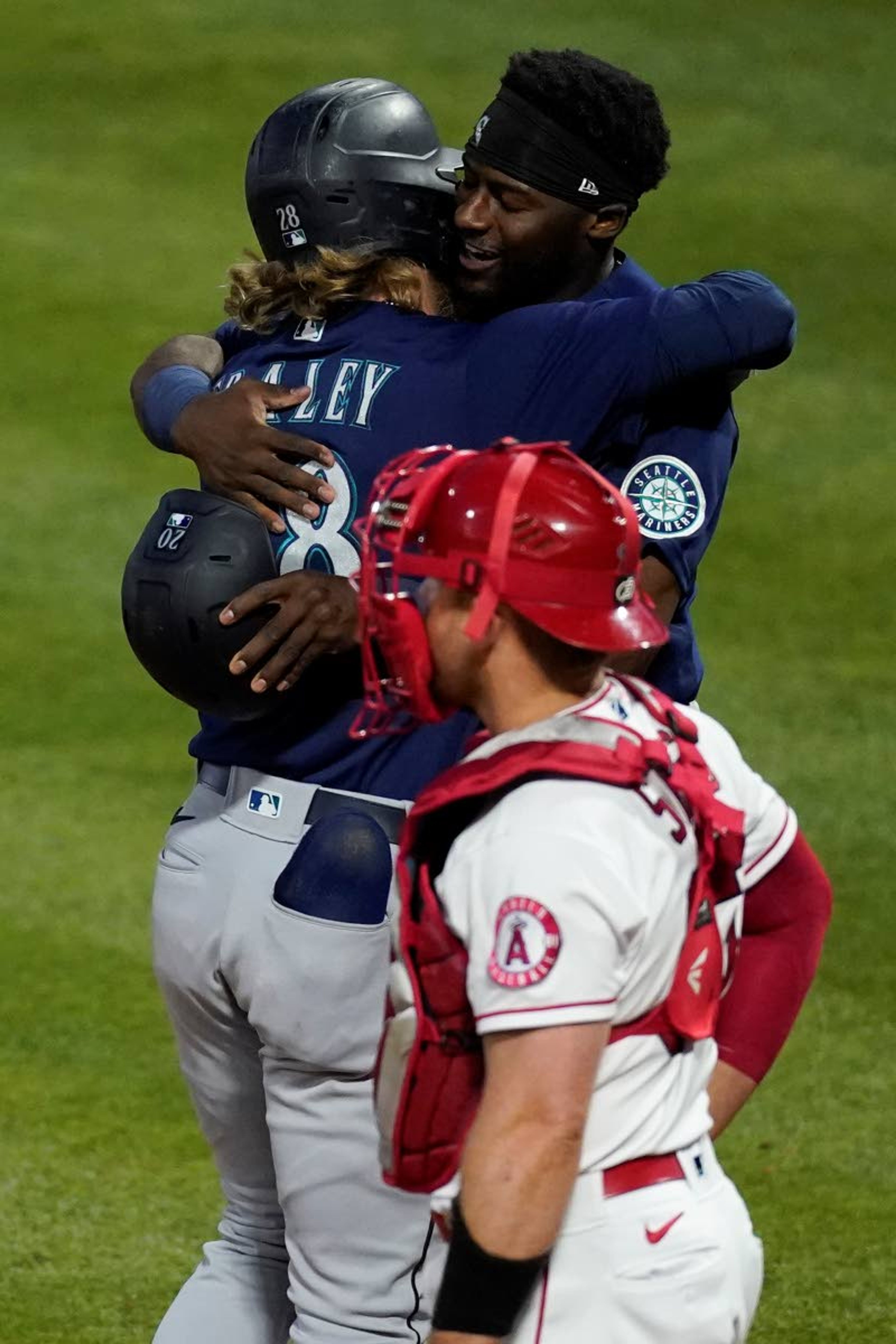 Seattle Mariners designated hitter Jake Fraley, top left, celebrates with Taylor Trammell, top right, after Fraley hit a grand slam home run during the fourth inning of a baseball game against the Los Angeles Angels Saturday, June 5, 2021, in Anaheim, Calif. Trammell, Mitch Haniger, and Ty France also scored. Los Angeles Angels catcher Max Stassi, center, reacts. (AP Photo/Ashley Landis)