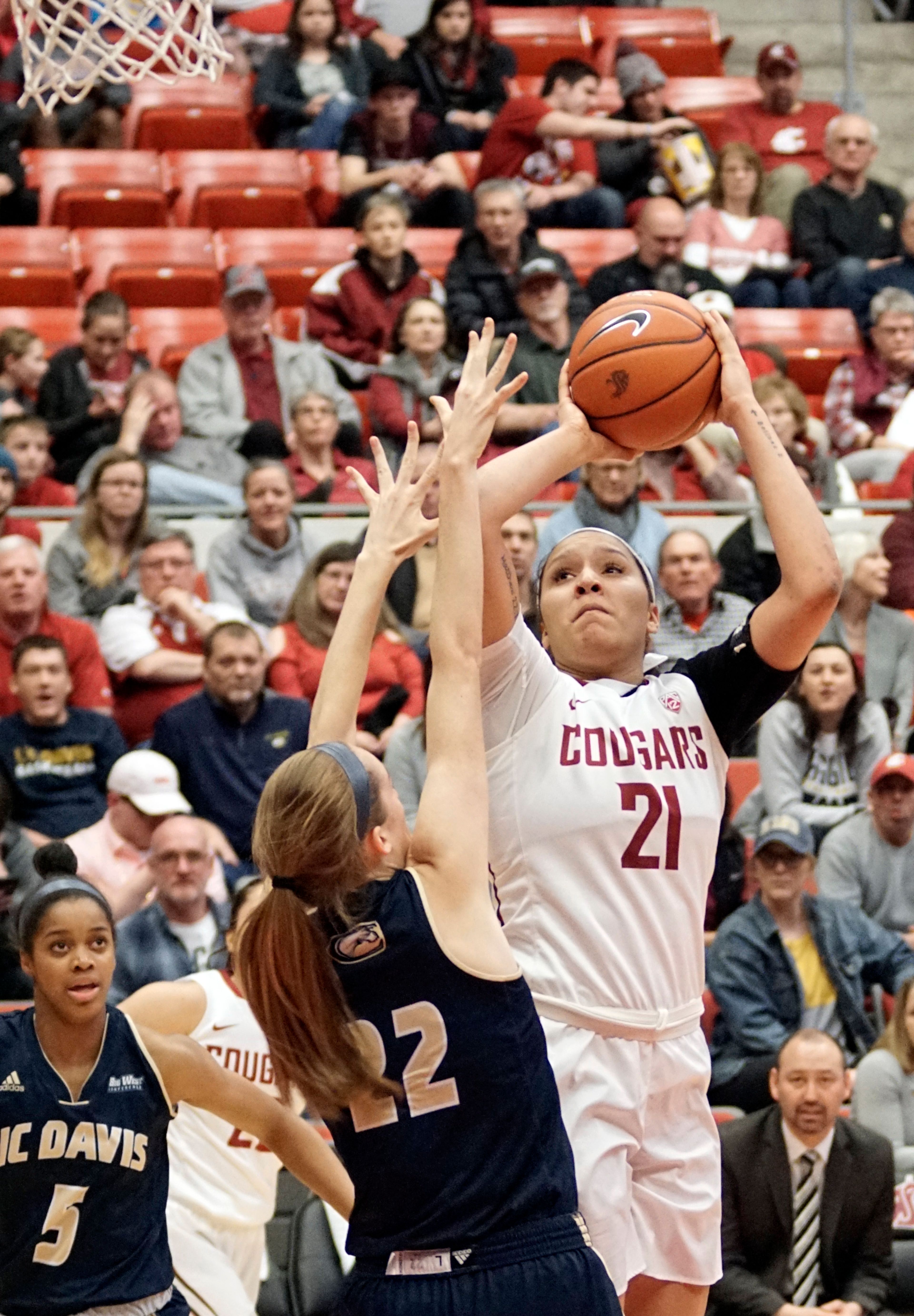 Sophomore WSU forward Nike McClure, 21, fires a jumpshot over UC Davis defender Morgan Bertsch (22) during a third round game of the WNIT at Beasely Coliseum Thursday night.