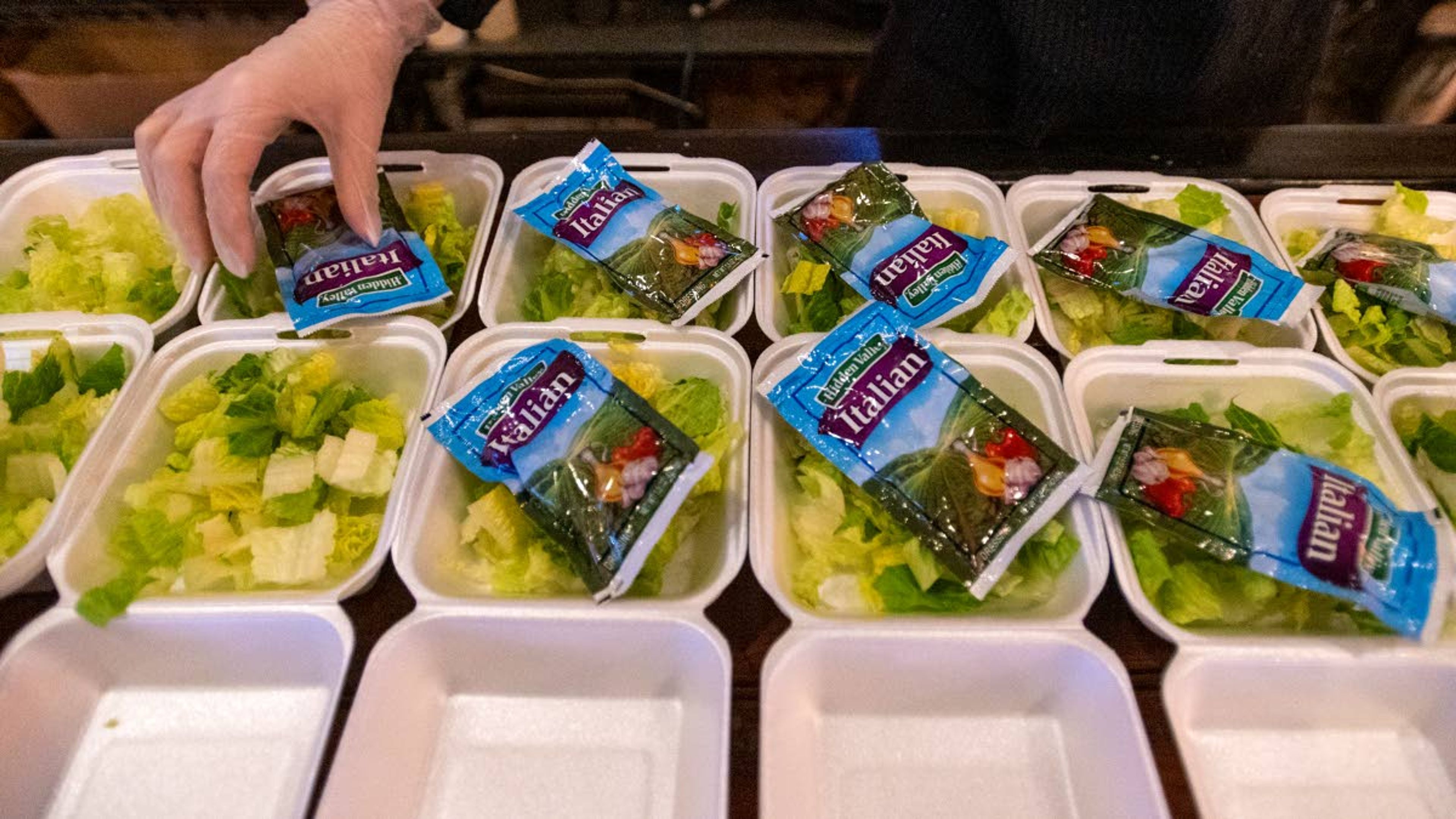 An employee with Oak on Main packages side salads for the Feeding Our Friends program Tuesday night at the restaurant in Pullman.