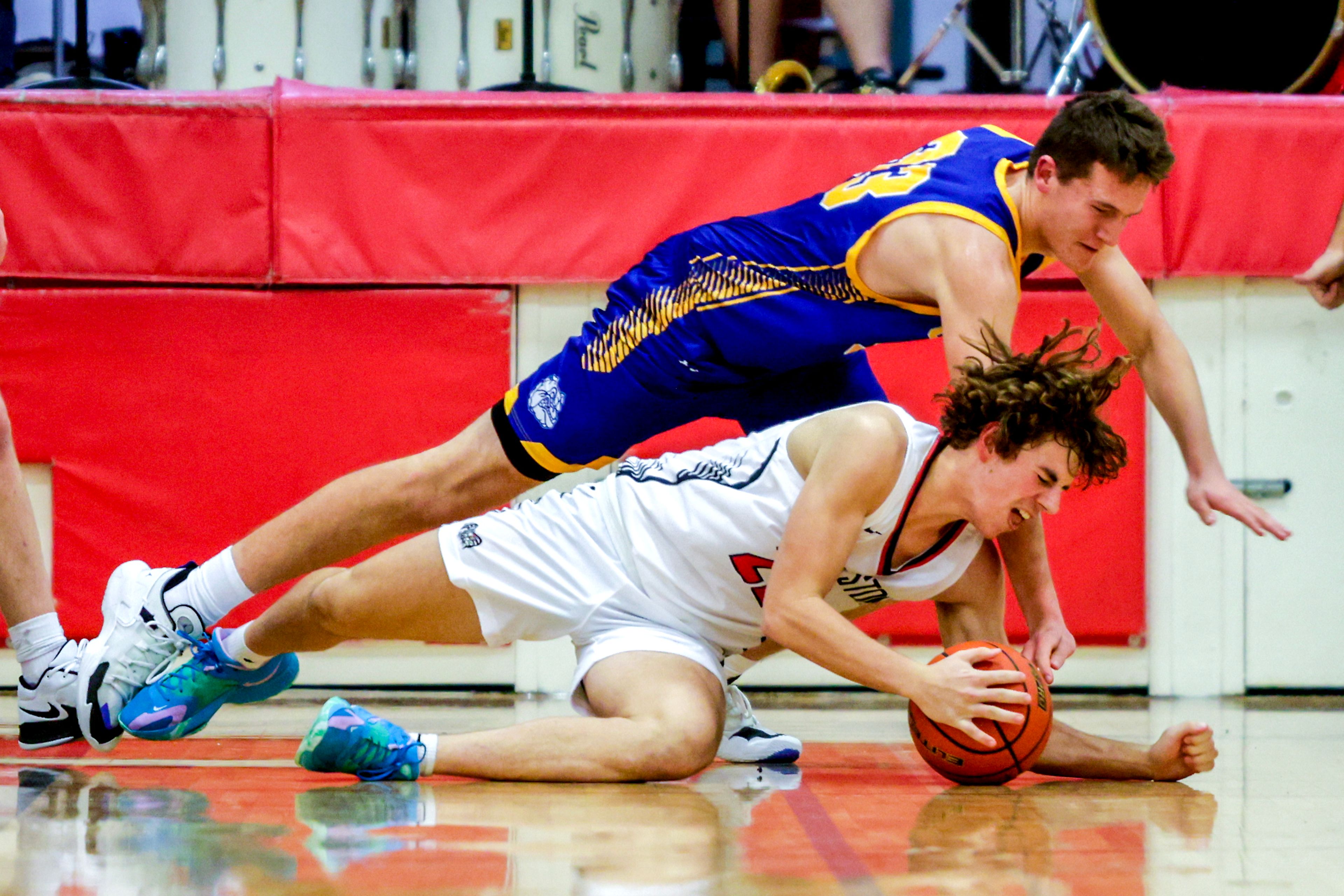 Clarkston forward Josh Hoffman grabs a loose ball over Colfax James Wigen in a quarter of a nonleague game Thursday at Clarkston.