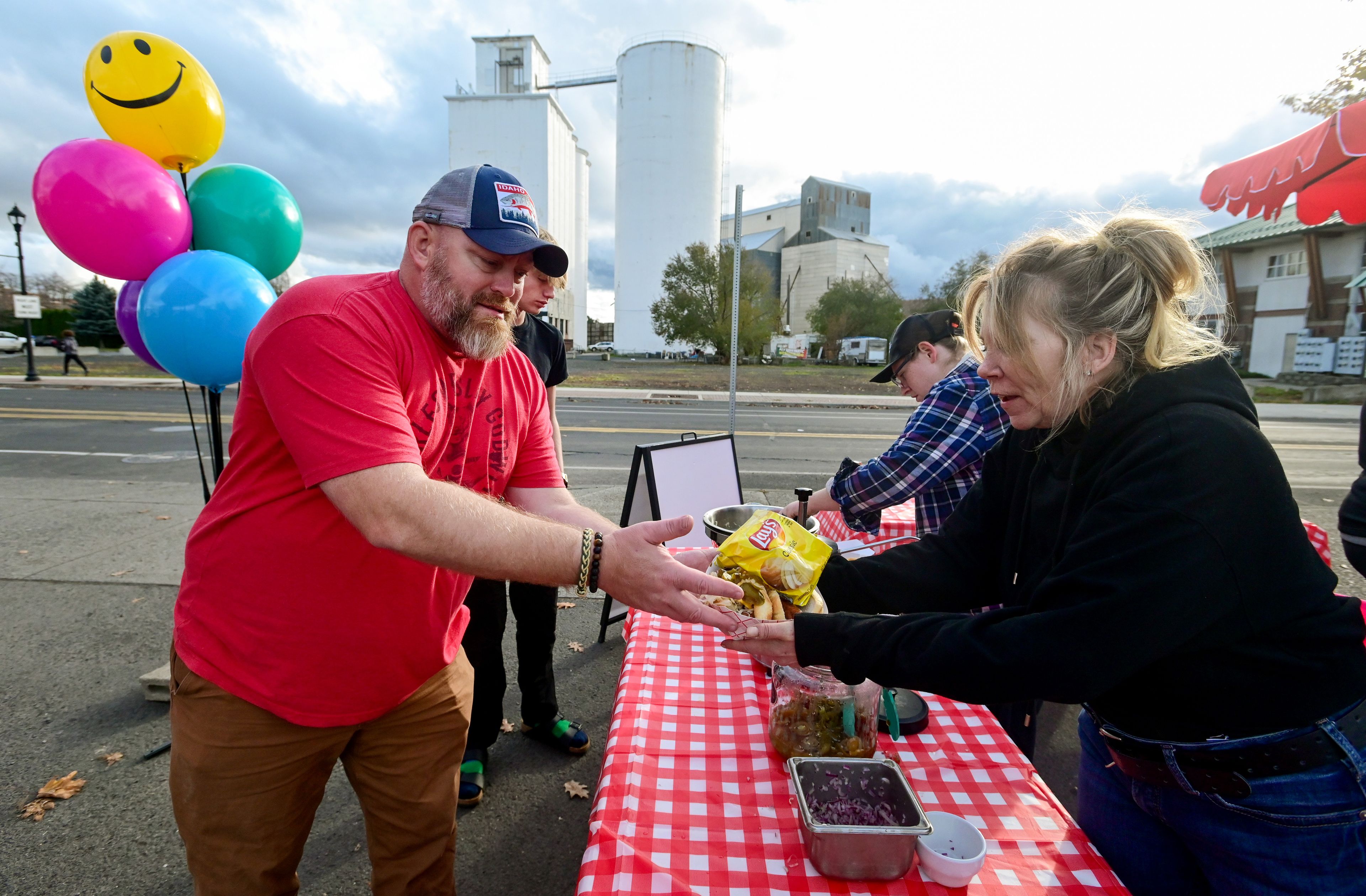 James Fields, left, buys hotdogs from the parking lot set up outside of Moscow Ale House in Moscow on Friday. Wendy Smiley Johnson, right, owner of Moscow Ale House and Wendy’s Weiners, opted to move the Ale House’s kitchen outside after losing heat from the gas line rupture outside of Pullman earlier this week.