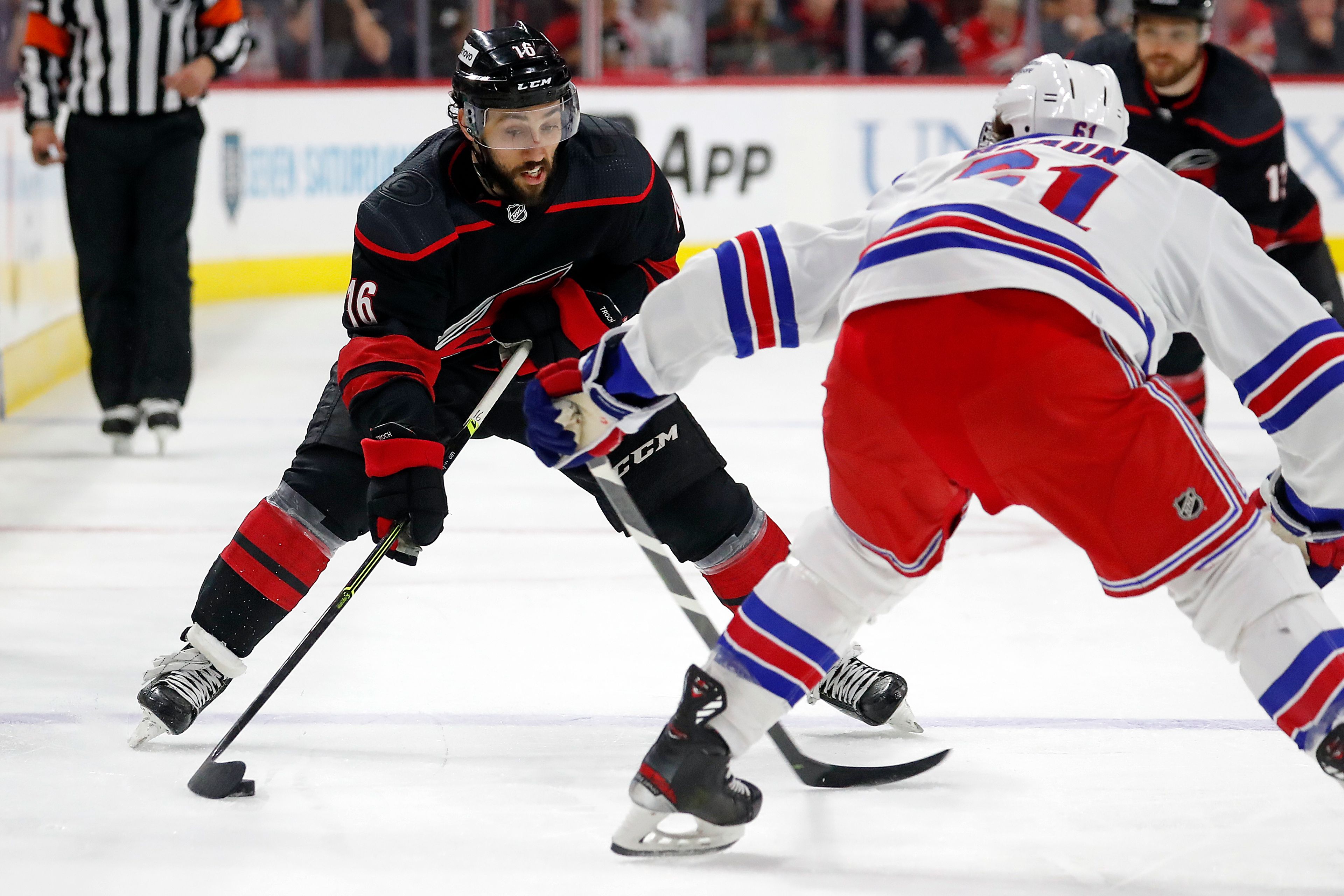 Carolina Hurricanes' Vincent Trocheck (16) moves the puck to challenge New York Rangers' Justin Braun (61) during the second period of Game 7 of an NHL hockey Stanley Cup second-round playoff series in Raleigh, N.C., Monday, May 30, 2022. (AP Photo/Karl B DeBlaker)