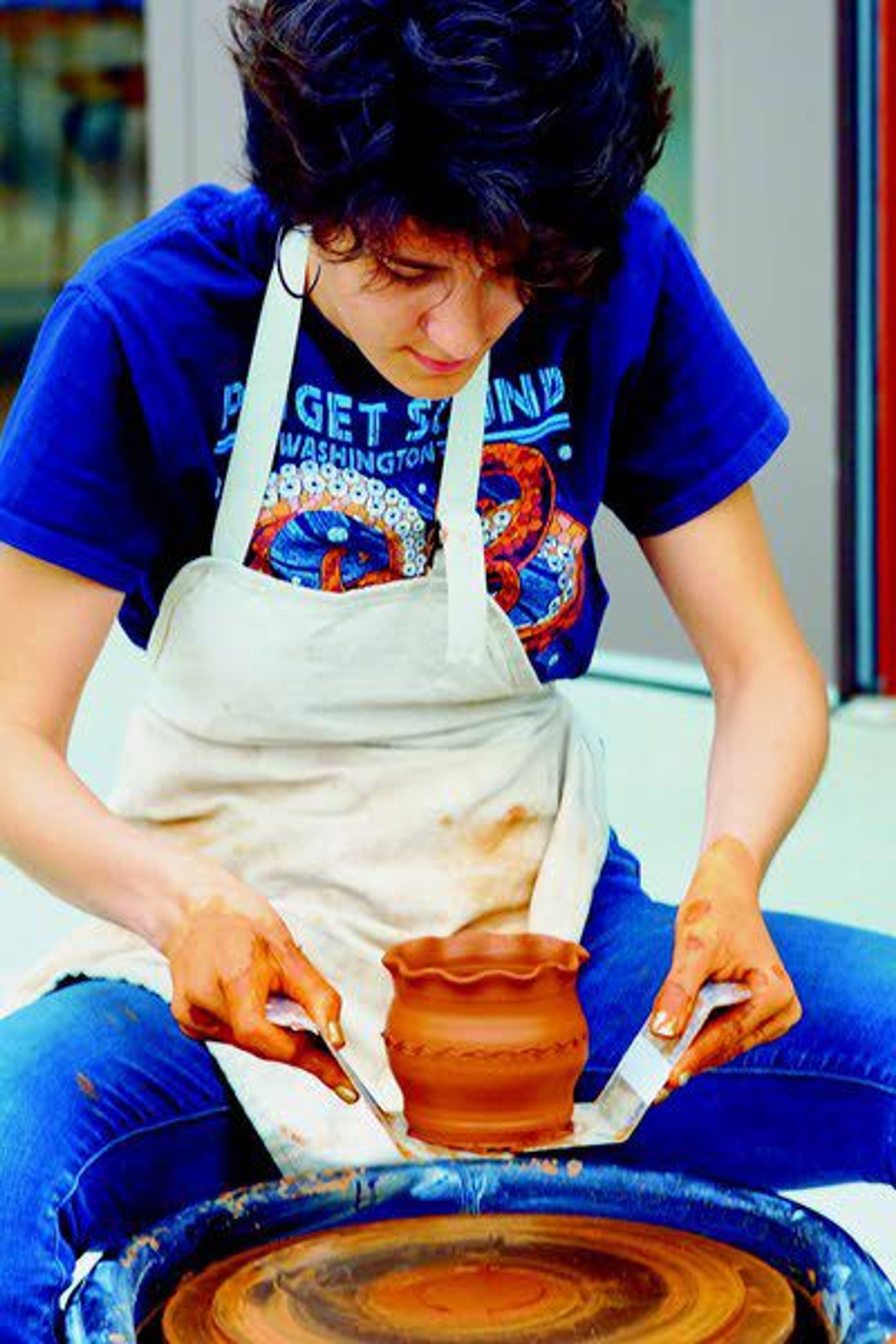 Haile Hunshaker lifts a pot off of a wheel Saturday evening at the Dahmen Barn in Uniontown during a fundraiser for a new kiln shed.