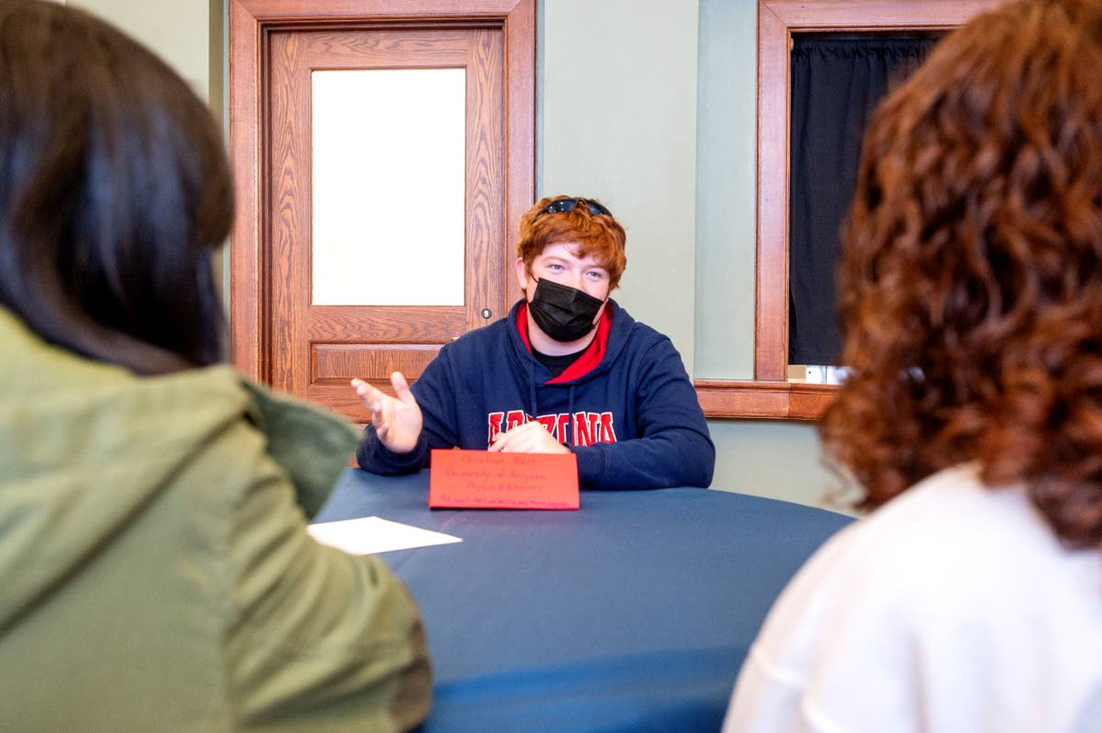 Christian Burt, a physics and astronomy major at the University of Arizona, speaks with Pullman High school juniors Mika Toyoda, left, and Frances Lindberg during a Palouse Pathways event at the 1912 Center in Moscow on Monday afternoon.