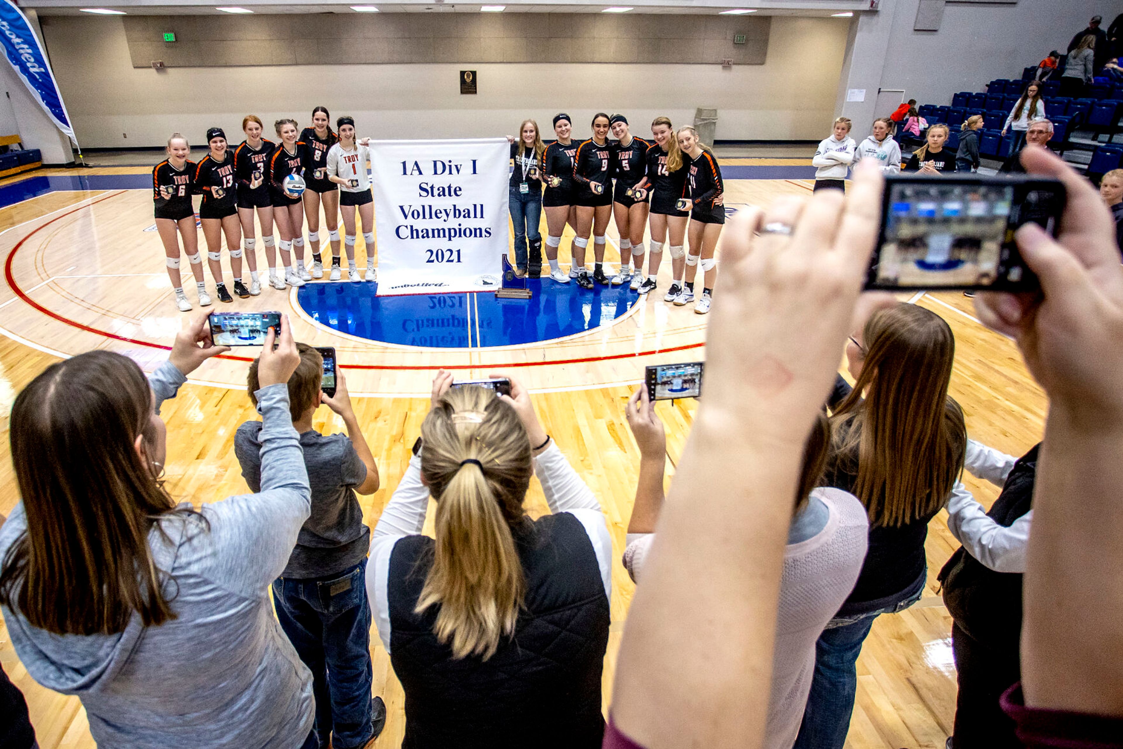 Parents and family take photos of the Troy volleyball team at the Lewis-Clark State College Athletic Center on Saturday. Troy defeated Grace in three sets to become the 1A DI state champions.