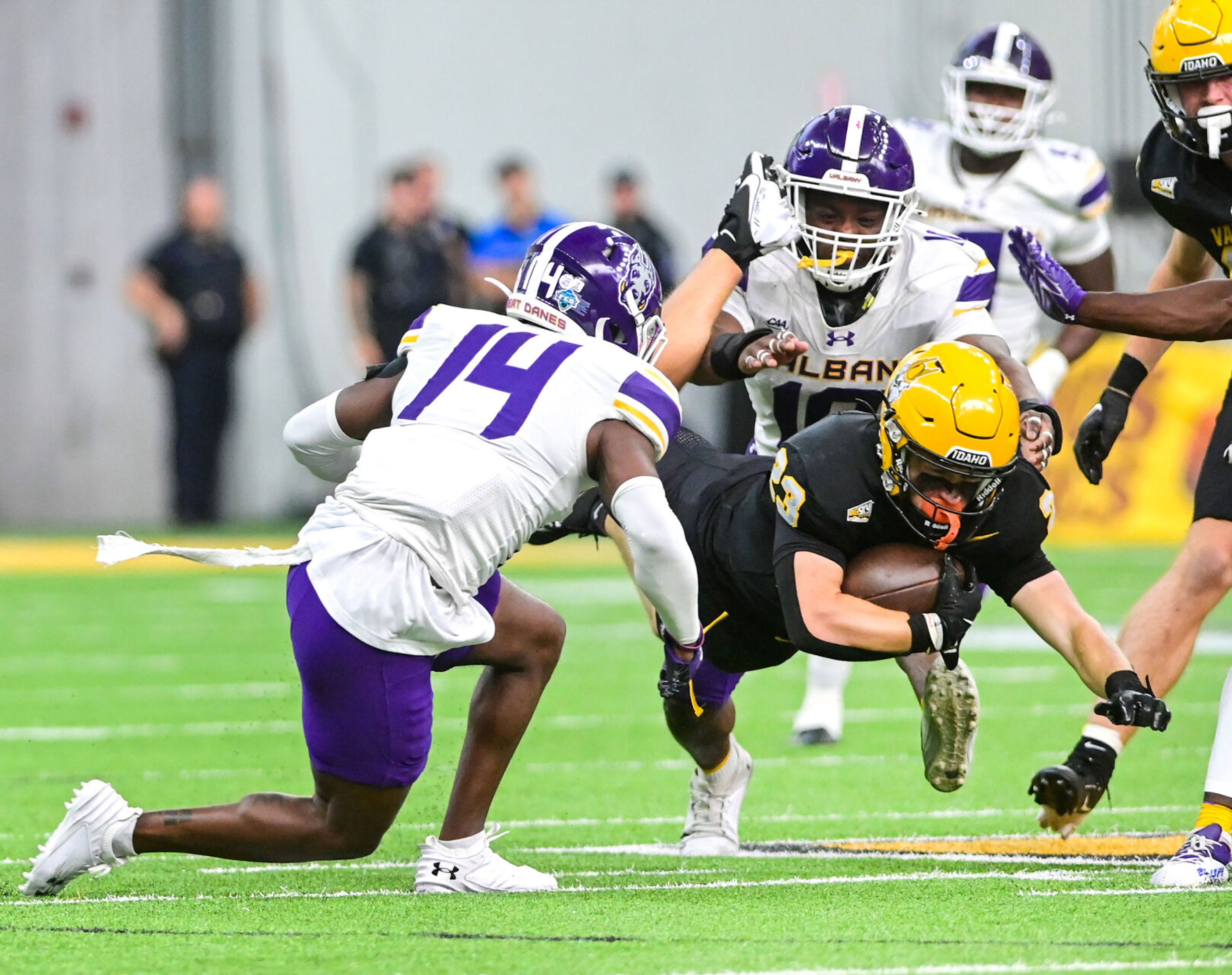 Idaho Vandals running back Art Williams dives before being tackled by UAlbany defenders Saturday at the P1FCU Kibbie Dome in Moscow.