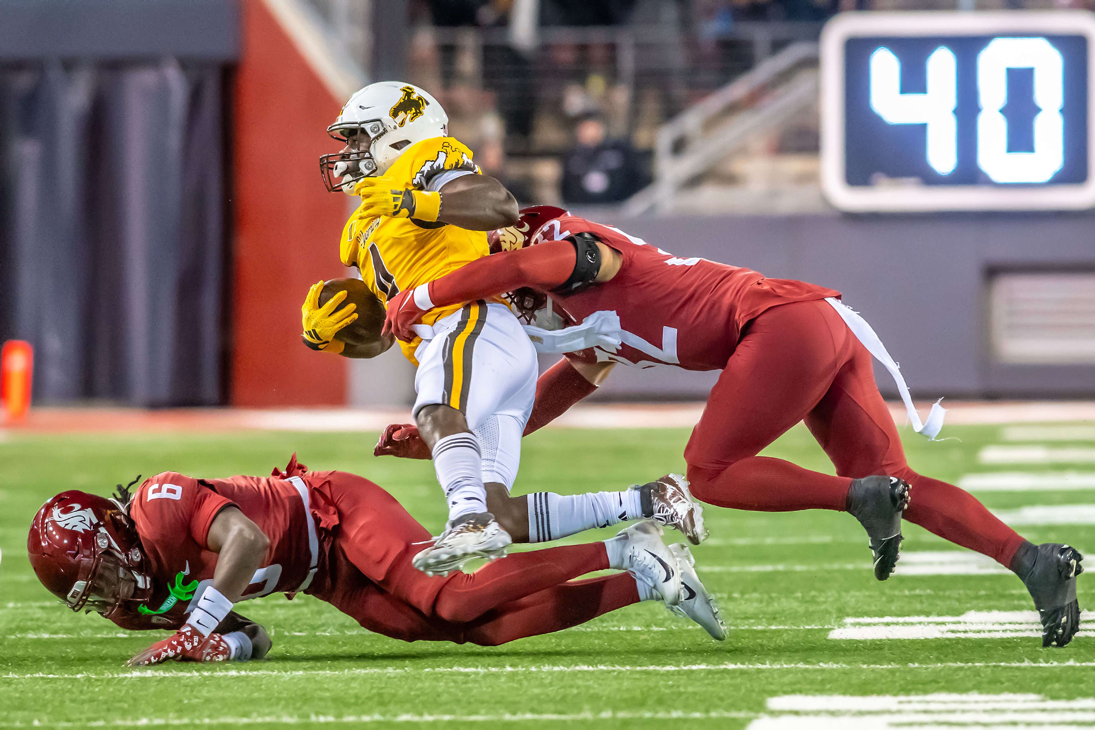 Washington State defensive back Adrian Wilson (6) and Washington State defensive back Warren Smith Jr. bring down Wyoming running back Harrison Waylee during a quarter of a college football game on Saturday, at Gesa Field in Pullman.