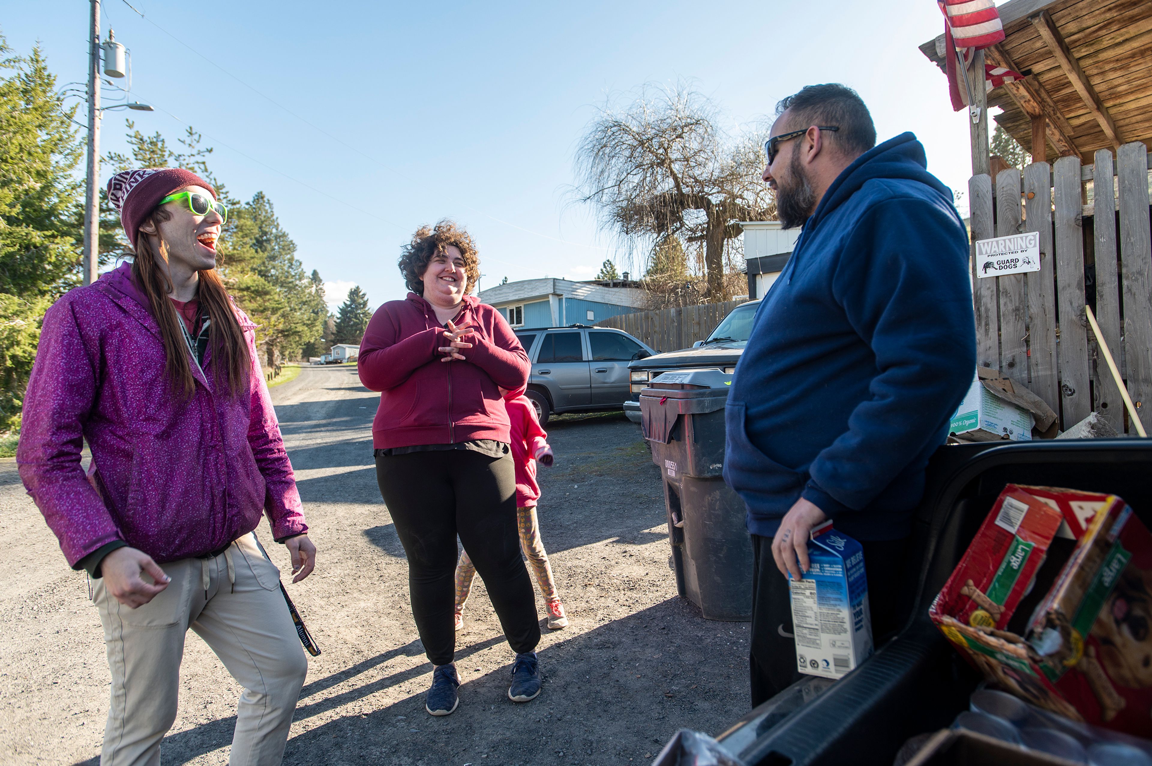 Zach Wilkinson/Daily News Olivia Moses, from left, and Hannah Kimbel, of Food Not Bombs of the Palouse, speak with Taylor Riggs after delivering food to him and his family Thursday afternoon at Appaloosa Court mobile home park in Moscow. “It’s hard to sum up and show my appreciation for all these guys do. With all the food they’ve provided and going to bat legally for this mobile park, it’s helped a lot of people around here. They don’t get enough credit,” Riggs said.