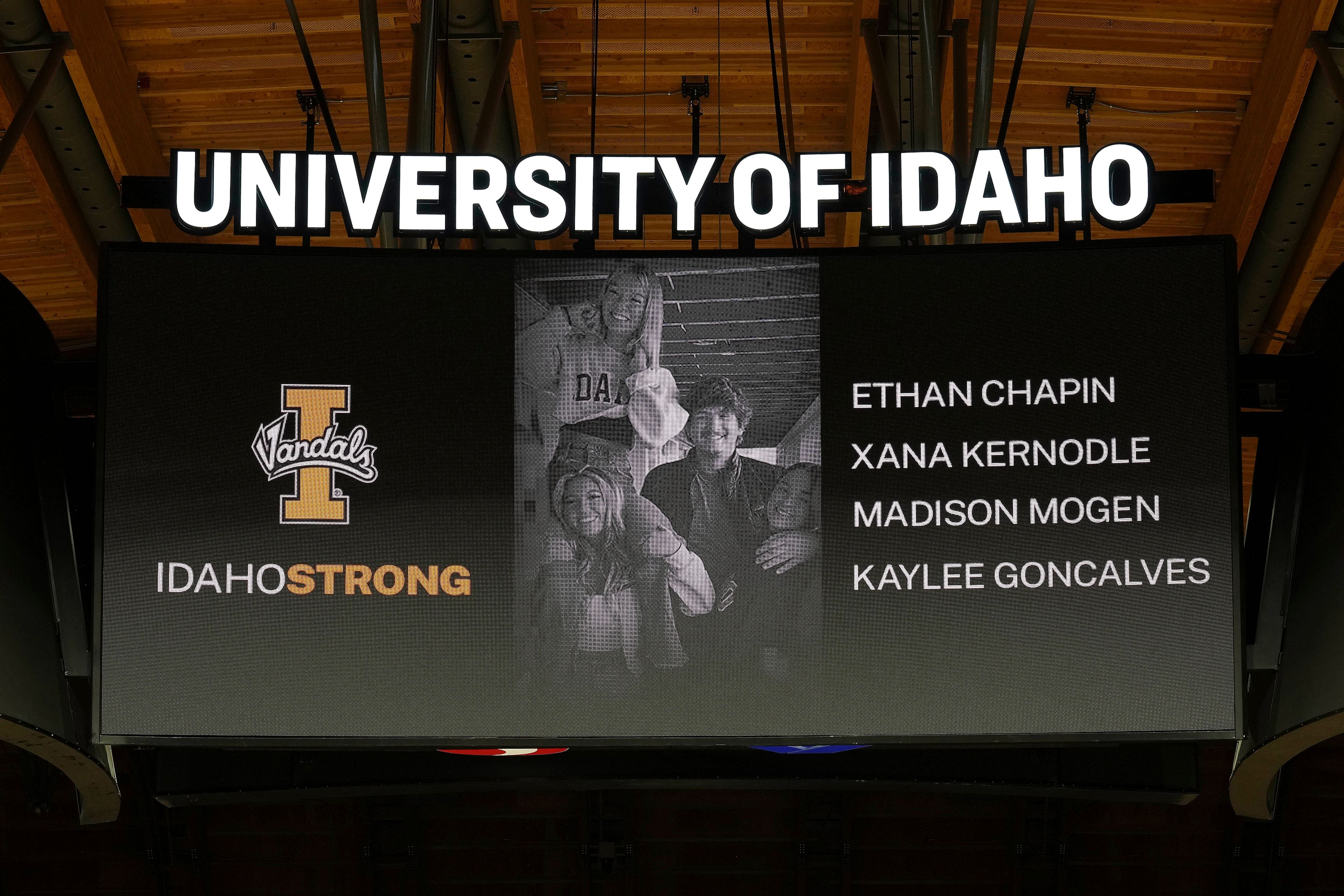 FILE - A photo and the names of four University of Idaho students who were killed over the weekend at a residence near campus are displayed during a moment of silence, Nov. 16, 2022, before an NCAA college basketball game in Moscow, Idaho. Investigators have yet to name a suspect in the stabbing deaths of four University of Idaho students who were found dead in a home near campus last month. But would-be armchair detectives and internet sleuths have come up with several of their own, the conclusions often based on conjecture and rumor. (AP Photo/Ted S. Warren, File)