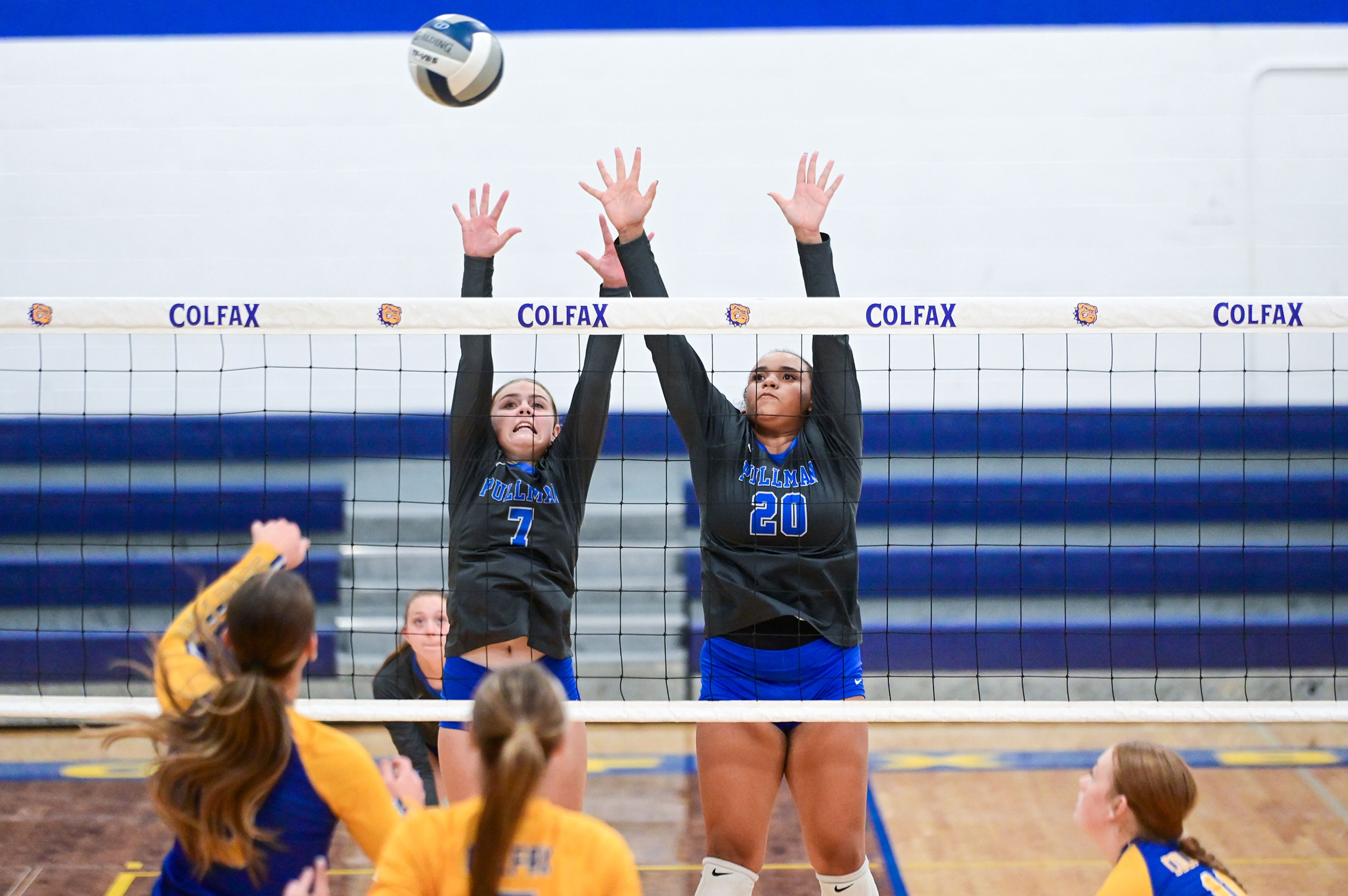 Pullman sophomore Camber Wolfe and junior Jasmyne Washington jump to block a hit from Colfax on Sept. 12 during a match in Colfax.