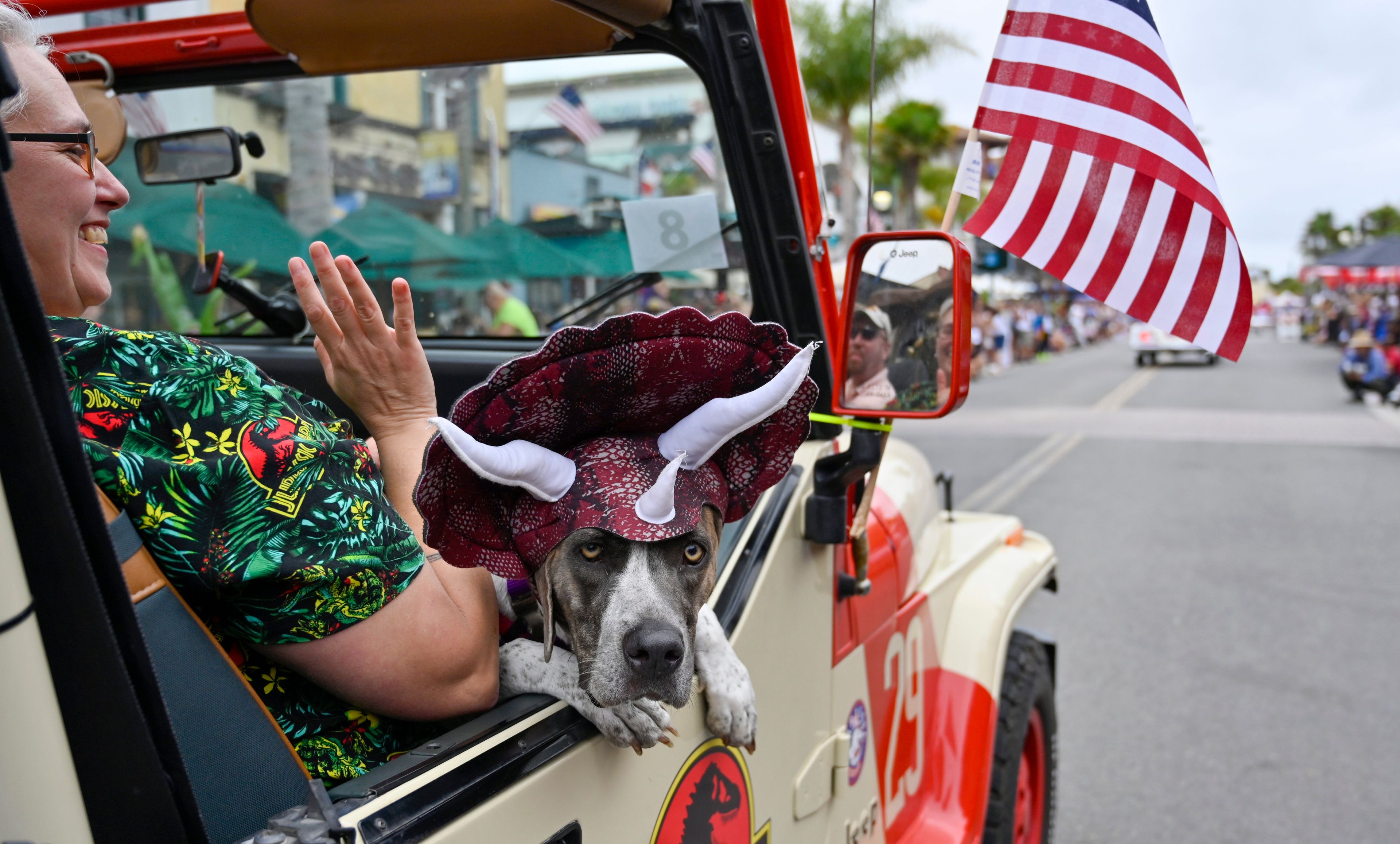 A dog dressed as a dinosaur sits in a Jurassic Park Jeep on Main Street during the 118th Huntington Beach 4th of July Parade in Huntington Beach, Calif., on Monday, July 4, 2022. (Jeff Gritchen/The Orange County Register via AP)