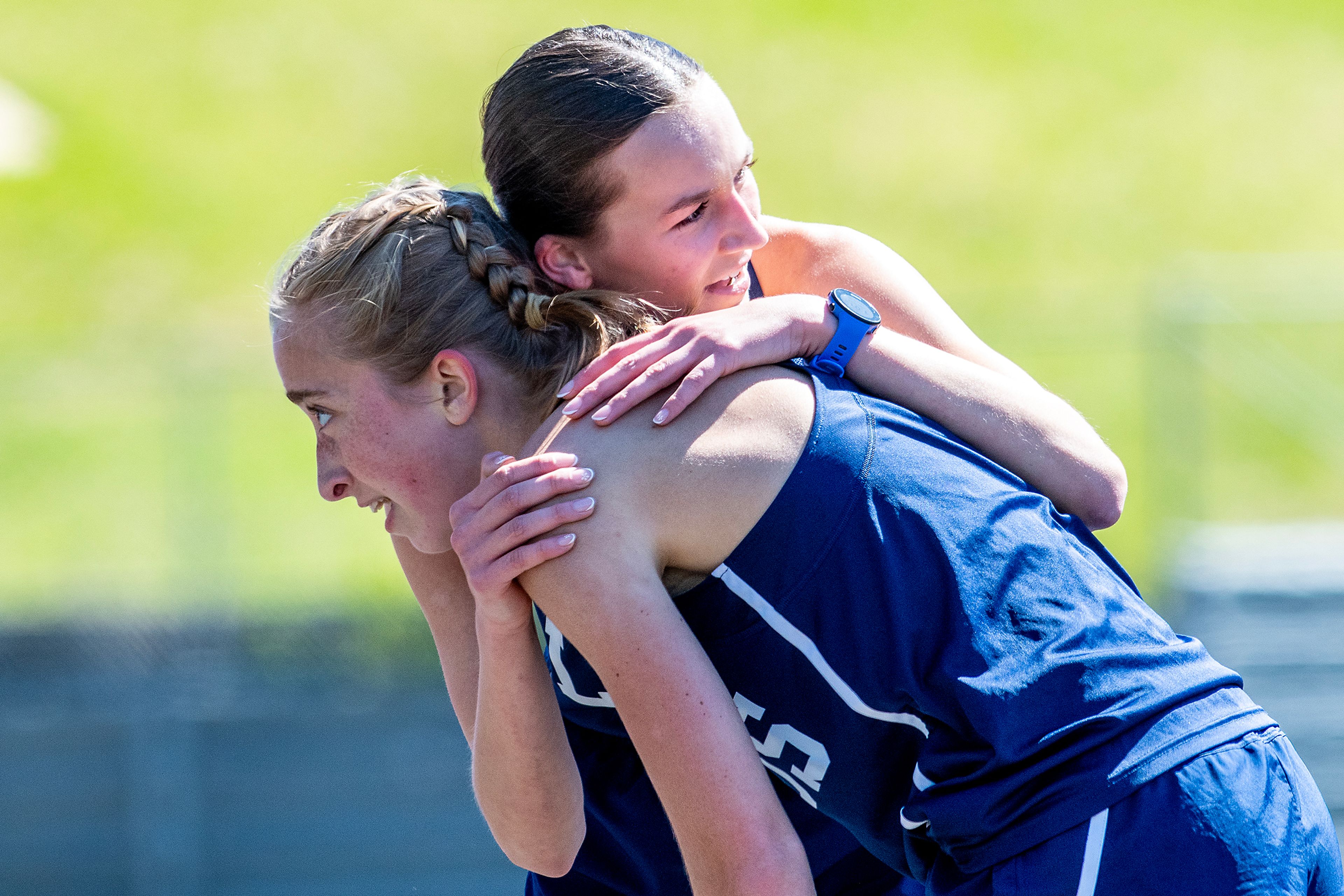 Logos’ Sara Casebolt hugs her teammate Mari Calene after finishing first in the 1,600-meter run while Calene finished fourth Thursday at the Meet of Champions Track Meet at Sweeney Track and Vollmer Bowl in Lewiston.