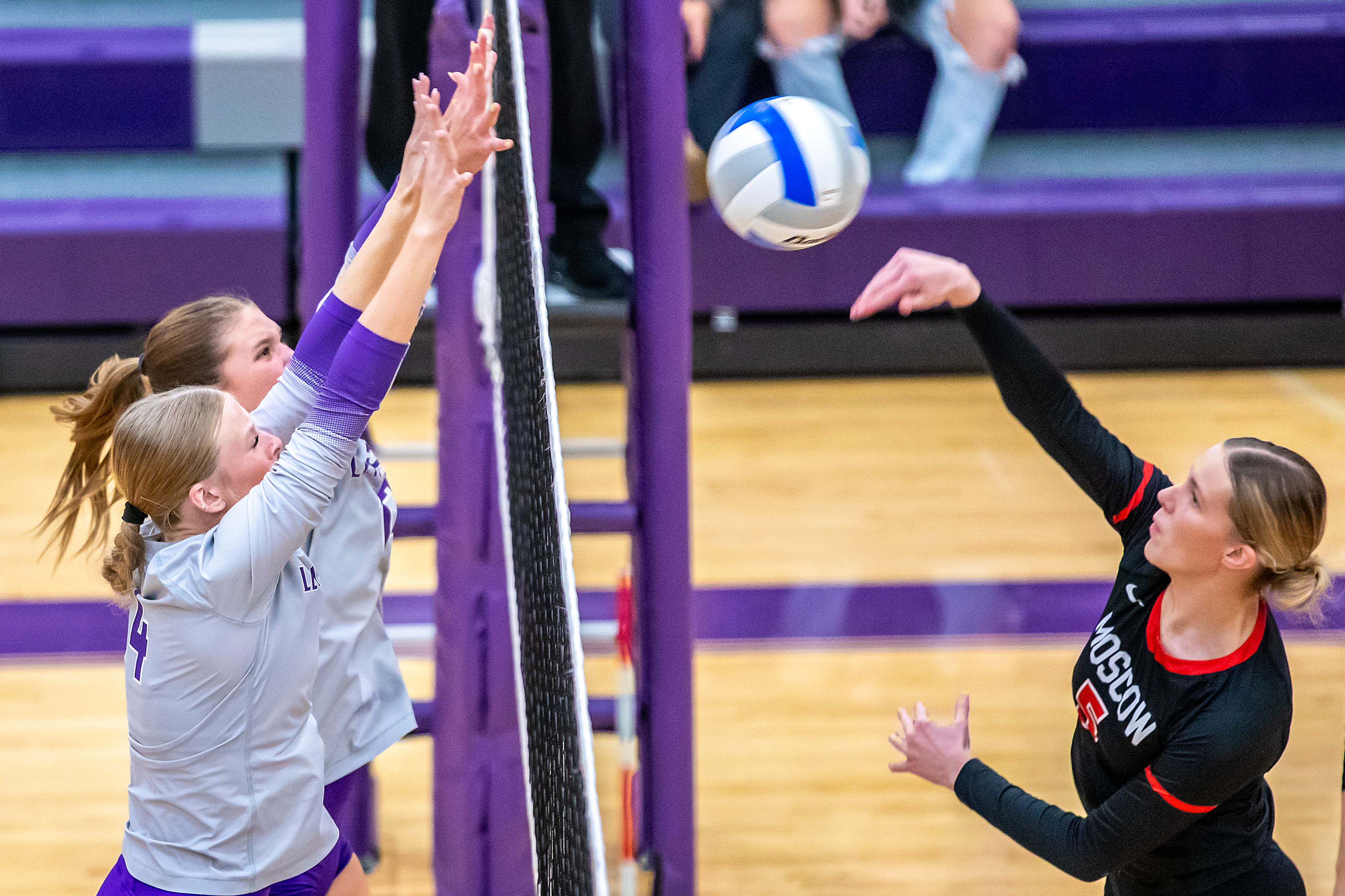 Moscow middle Jacque Williams spikes the ball as Lewiston middle blocker Jordynn Albright (4) and Addy McKarcher defend in a 5A district tournament match Tuesday in Lewiston.