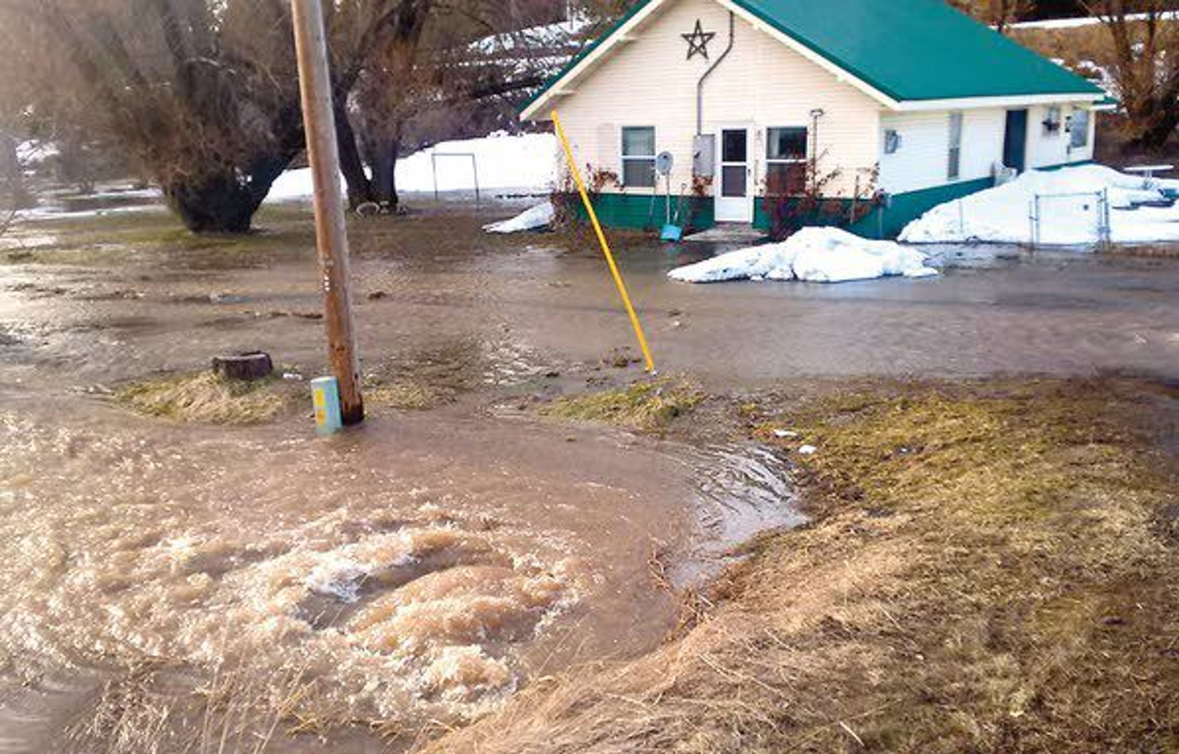 Water from a flooding creek flows past a house Friday near state Highway 8 a few miles west of Troy between Spence and Driscoll Ridge roads.