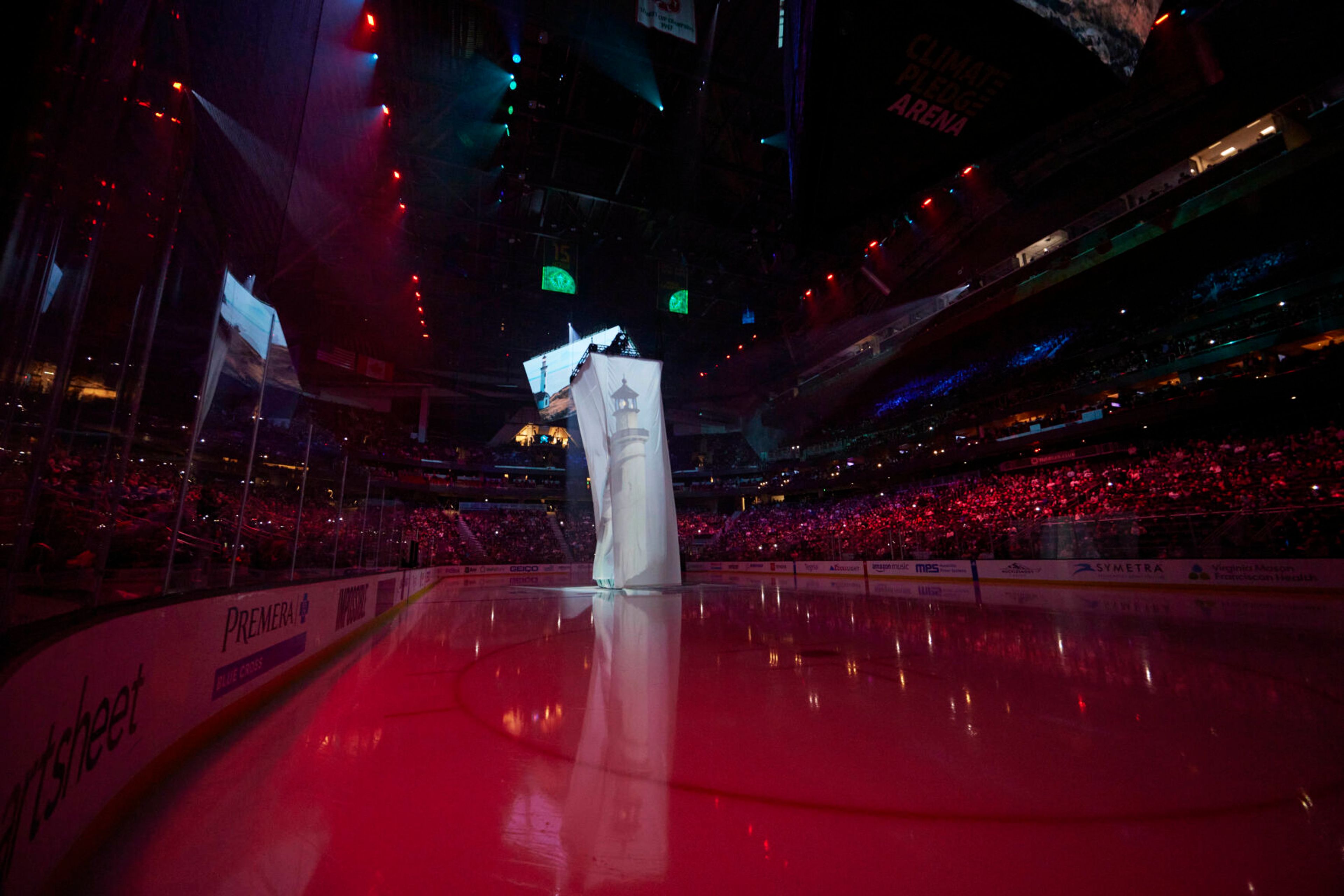 An image of a lighthouse is projected during pregame introductions of the Seattle Kraken NHL hockey team before a game against the St. Louis blues in Seattle, Wednesday, Oct. 19, 2022. With Hollywood filmmaker Jerry Bruckheimer as part of the ownership group, the Seattle Kraken were always going to have a big cinematic element to any video production the team produced. (AP Photo/John Froschauer)