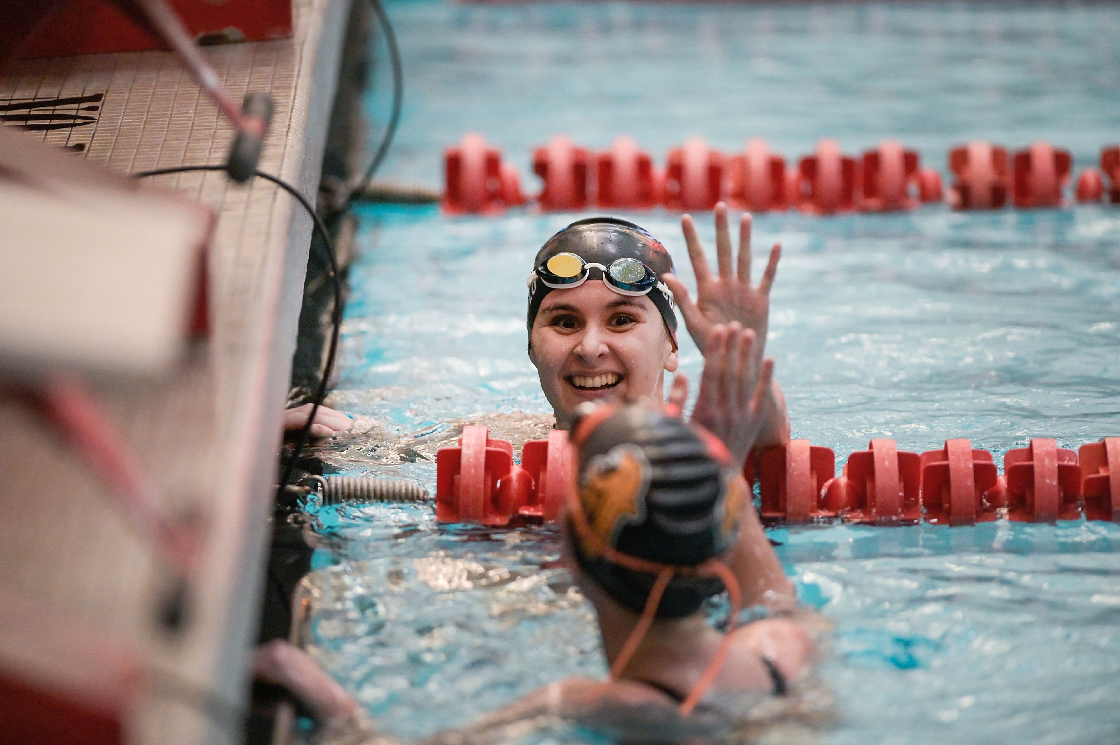 Pullman senior Kiara Donolo high-fives Zillah sophomore Kellee Muffett competing in a 200-yard individual medley Thursday at the Eastern Washington District Swim Championship at Washington State University in Pullman.