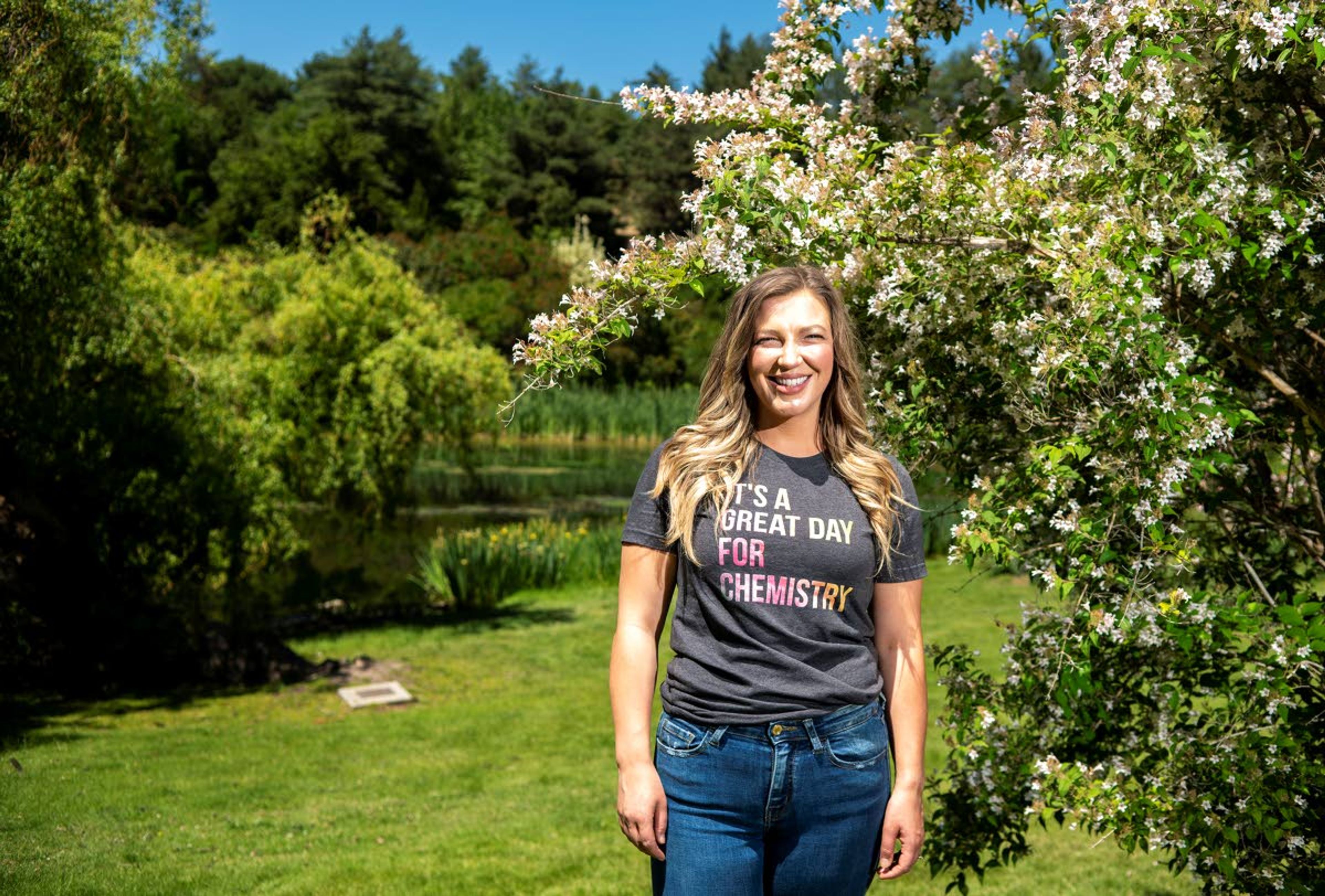 Johanna Brown, wearing one of her “Friday nerdy teeshirts,” poses for a photo underneath a “Pink Cloud” beauty bush in the University of Idaho Arboretum and Botanical Garden on Friday afternoon. Brown, a chemistry teacher at Pullman High School, was named one of six Washington math and science teacher finalists for the Presidential Award for Excellence in Math and Science Teaching Award.