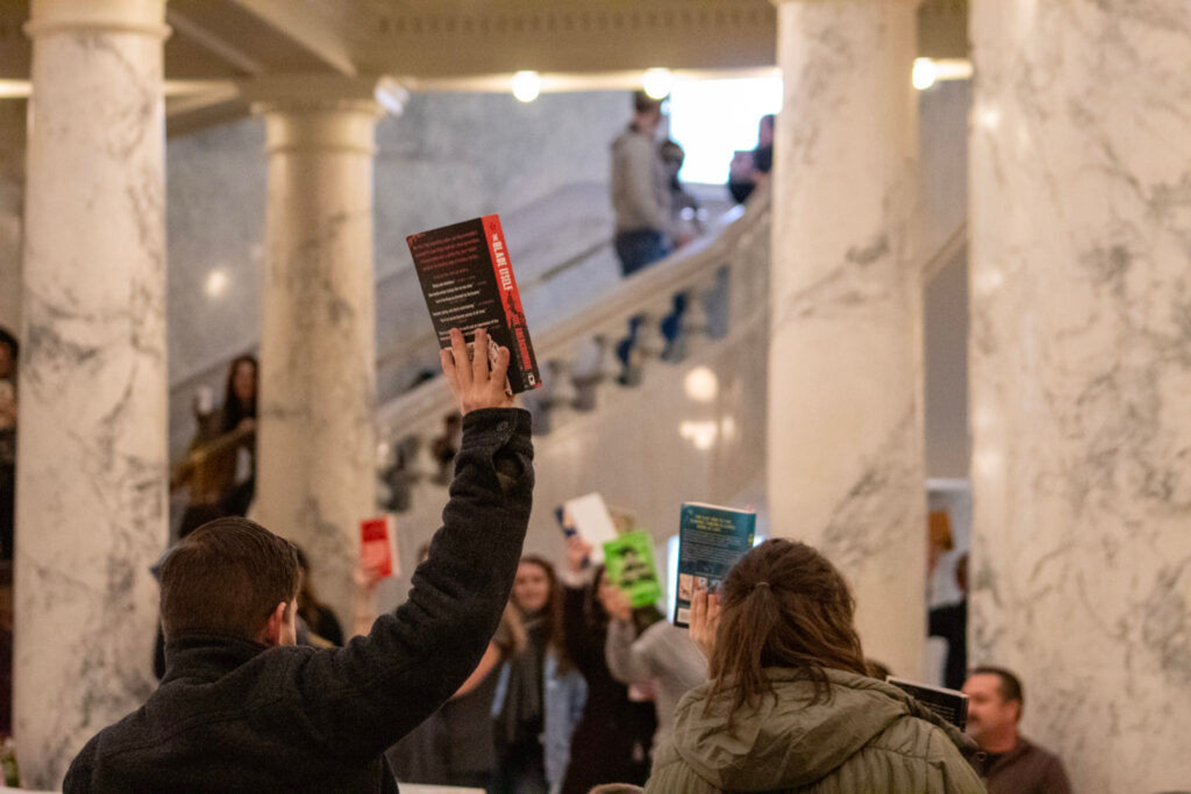 Attendees hold books in support of Idaho libraries at the Idaho Freedom to Read-in event at the Idaho Capitol Building.