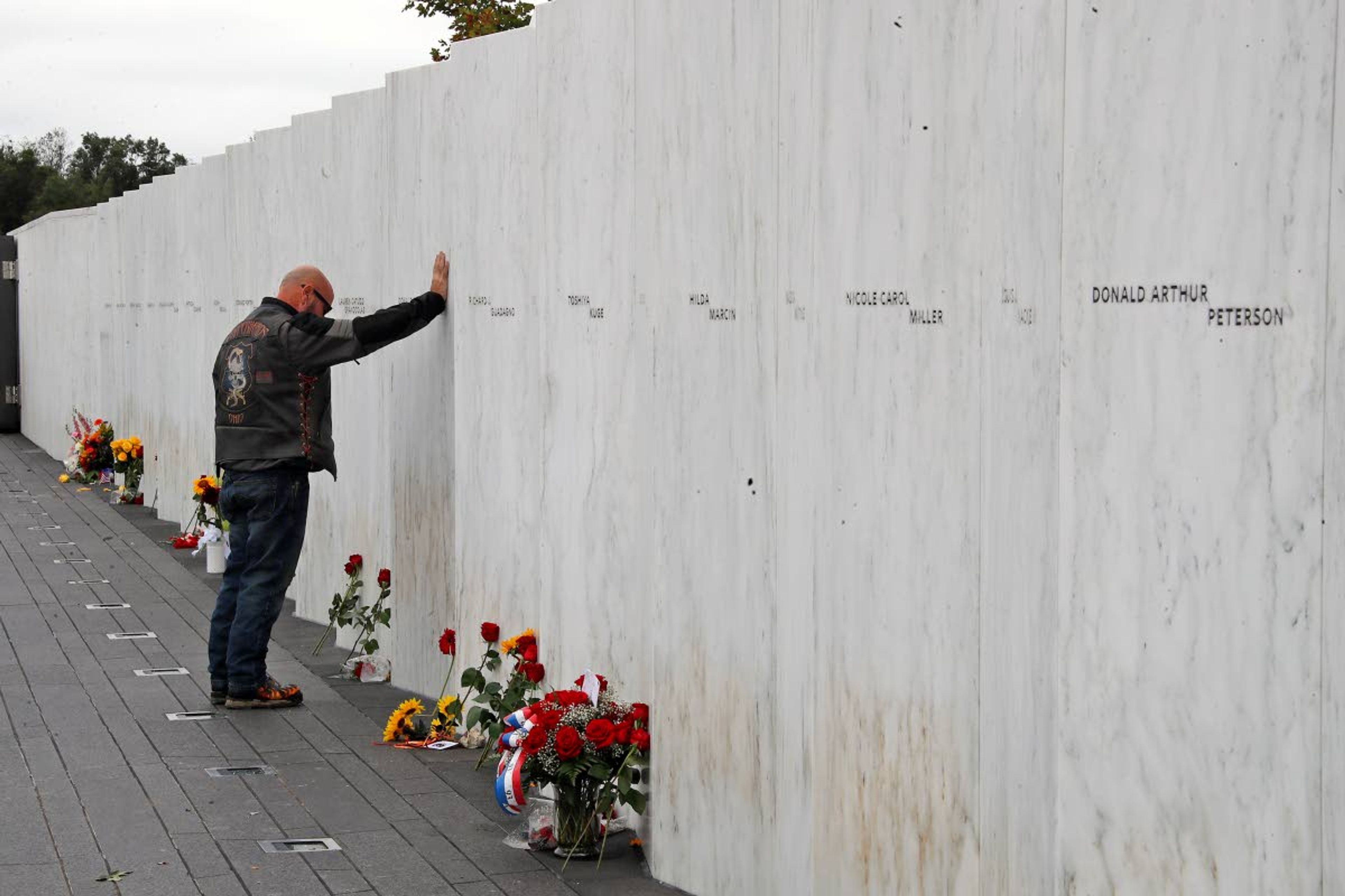 FILE - In this Sept. 11, 2018, file photo, a visitor to the Flight 93 National Memorial in Shanksville, Pa., pays his respects at the Wall of Names after a Service of Remembrance, as the nation marked the 17th anniversary of the Sept. 11, 2001, attacks. President Donald Trump and Democratic challenger Joe Biden plan to attend a truncated ceremony at the Flight 93 National Memorial in Pennsylvania. (AP Photo/Gene J. Puskar, File)