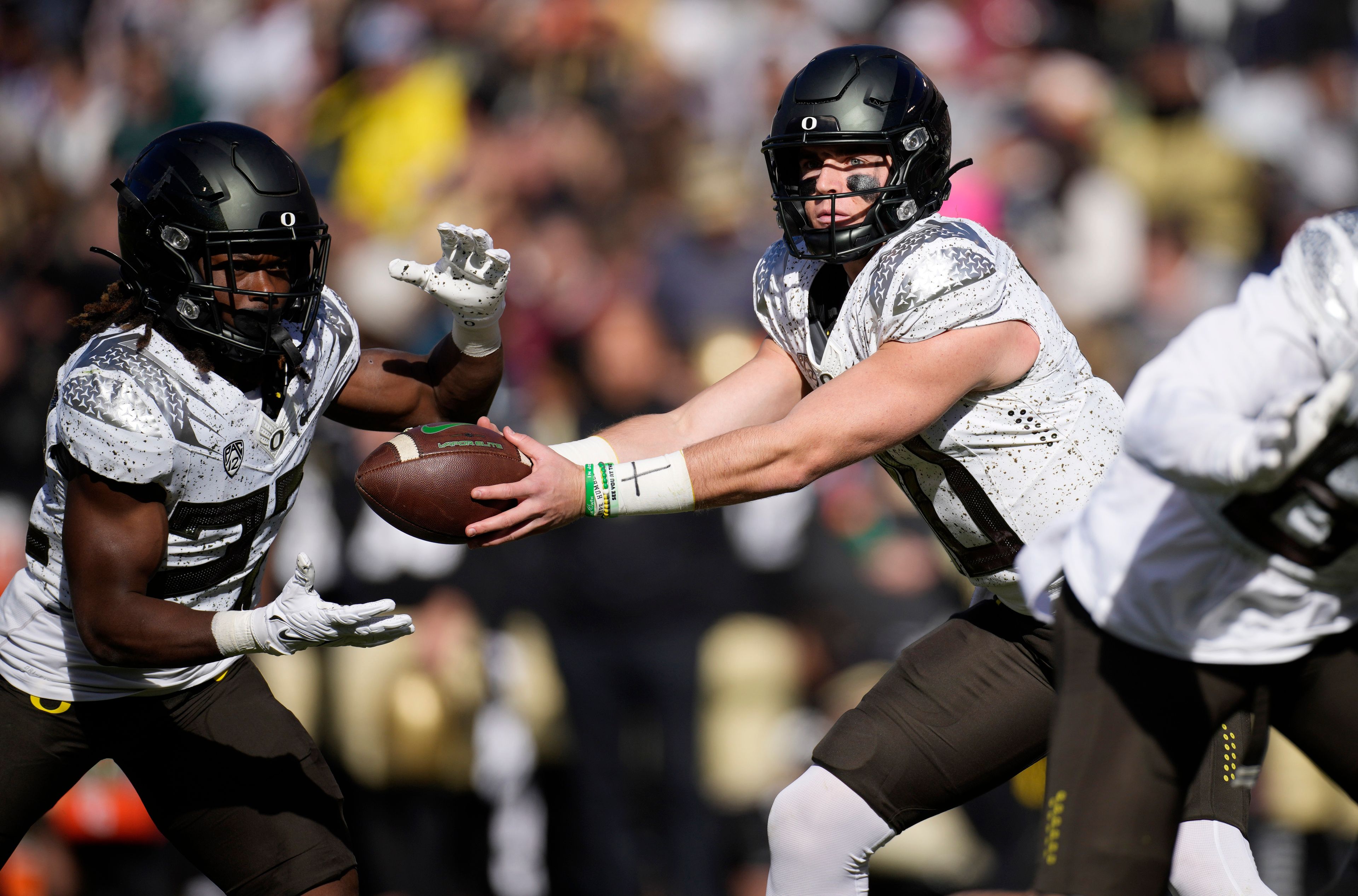 Oregon quarterback Bo Nix, right, hands off the ball to running back Noah Whittington in the first half of an NCAA college football game against Colorado, Saturday, Nov. 5, 2022, in Boulder, Colo. (AP Photo/David Zalubowski)