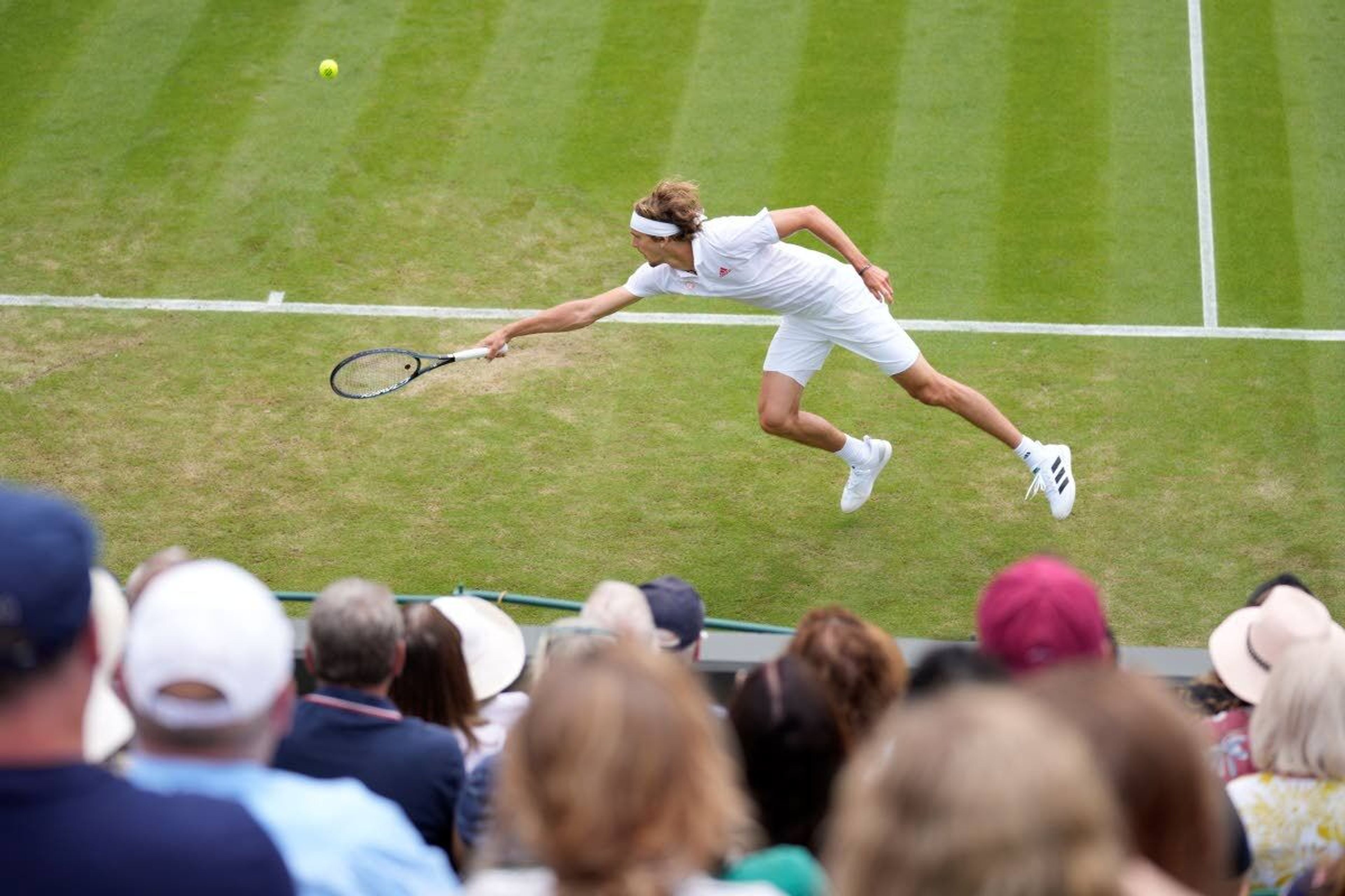 Germany's Alexander Zverev plays a return to Tennys Sandgren of the US during the men's singles second round match on day four of the Wimbledon Tennis Championships in London, Thursday July 1, 2021. (AP Photo/Kirsty Wigglesworth)