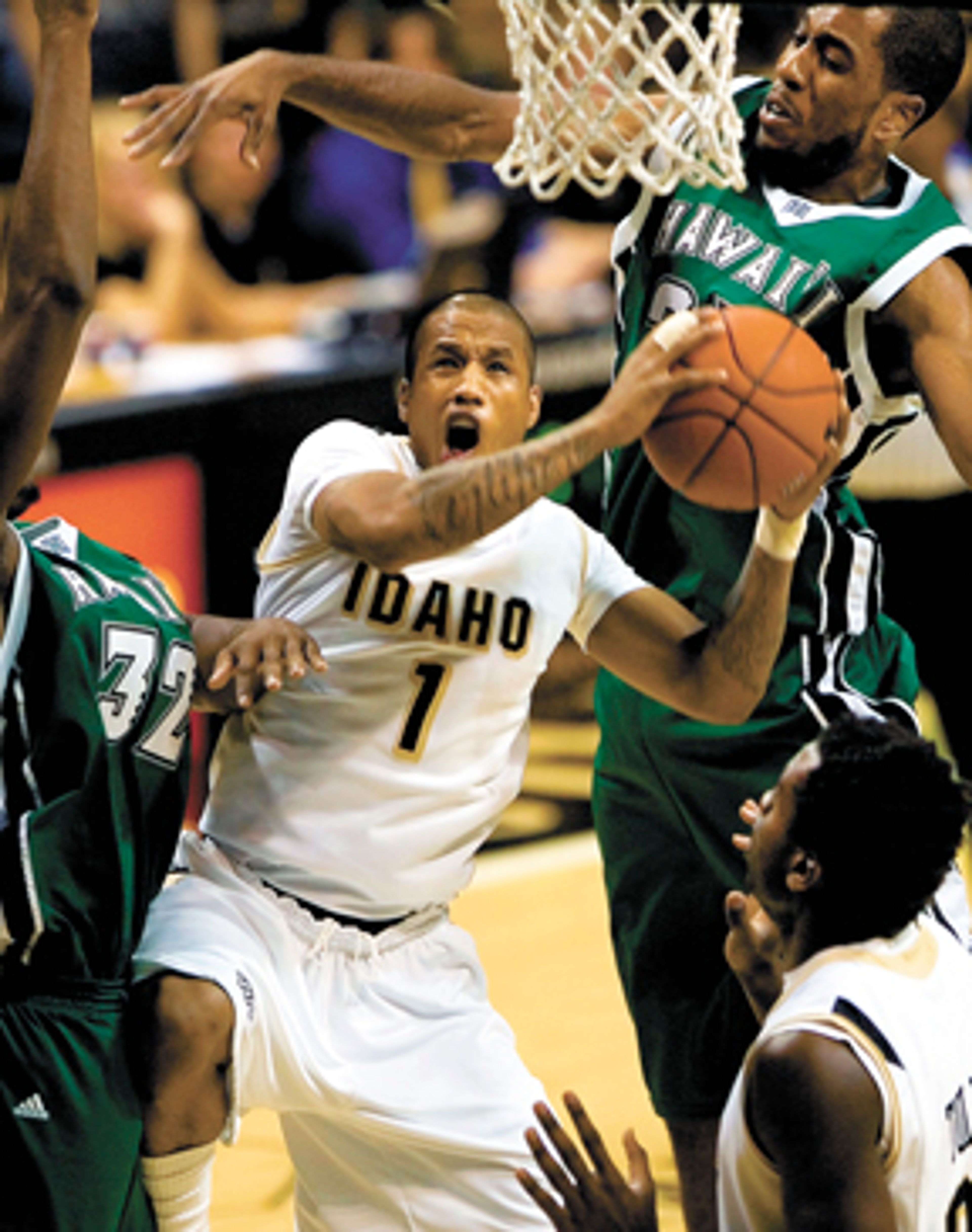 Idaho guard Mac Hopson (1) flies between Hawaii forwards Brandon
Adams (32) and Paul Campbell, upper right, as Luiz Toledo, lower
right, watches during the first half of the Vandals 78-69 win over
the Rainbow Warriors in an NCAA college basketball game Saturday,
March 6, 2010, at the Cowan Spectrum in Moscow. Hopson scored 15
points and dished 11 assists in his final regular season game in
Moscow.