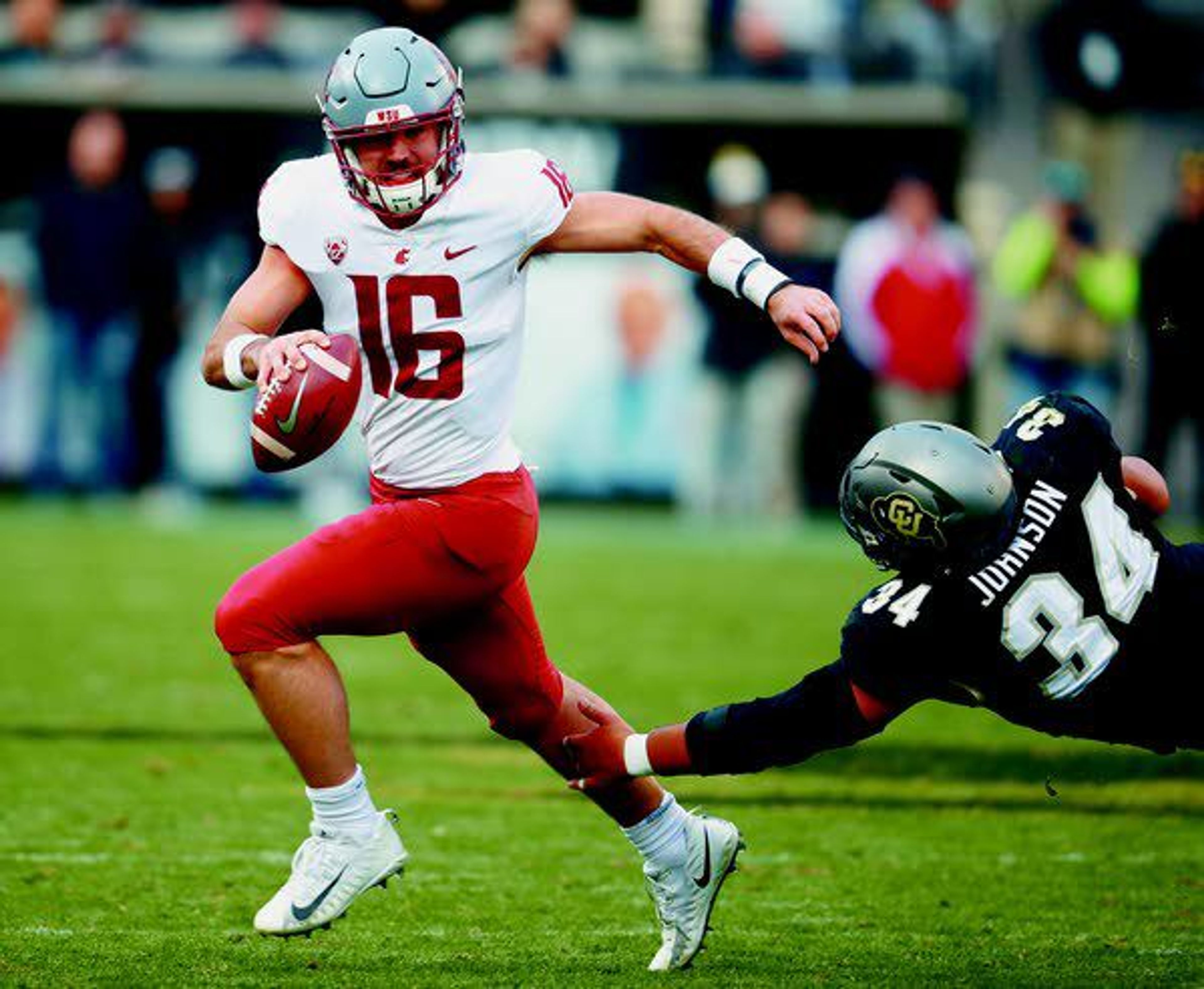 Washington State quarterback Gardner Minshew, left, scrambles away from Colorado defensive lineman Mustafa Johnson in the second half of an NCAA football game Nov. 10 in Boulder, Colo.