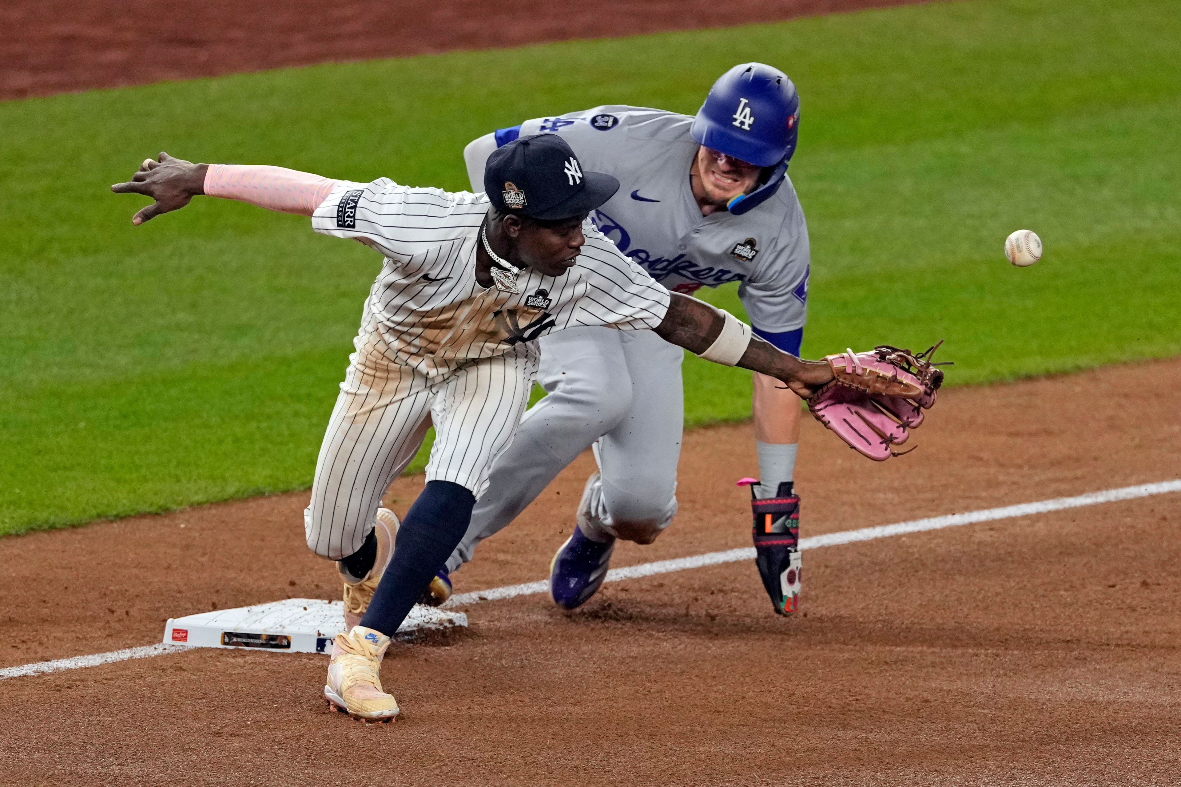 Los Angeles Dodgers' KikÃ© HernÃ¡ndez, right, is safe at third as New York Yankees third baseman Jazz Chisholm Jr. reaches for a throw from shortstop Anthony Volpe during the fifth inning in Game 5 of the baseball World Series, Wednesday, Oct. 30, 2024, in New York. Volpe was charged with a throwing error. (AP Photo/Seth Wenig)