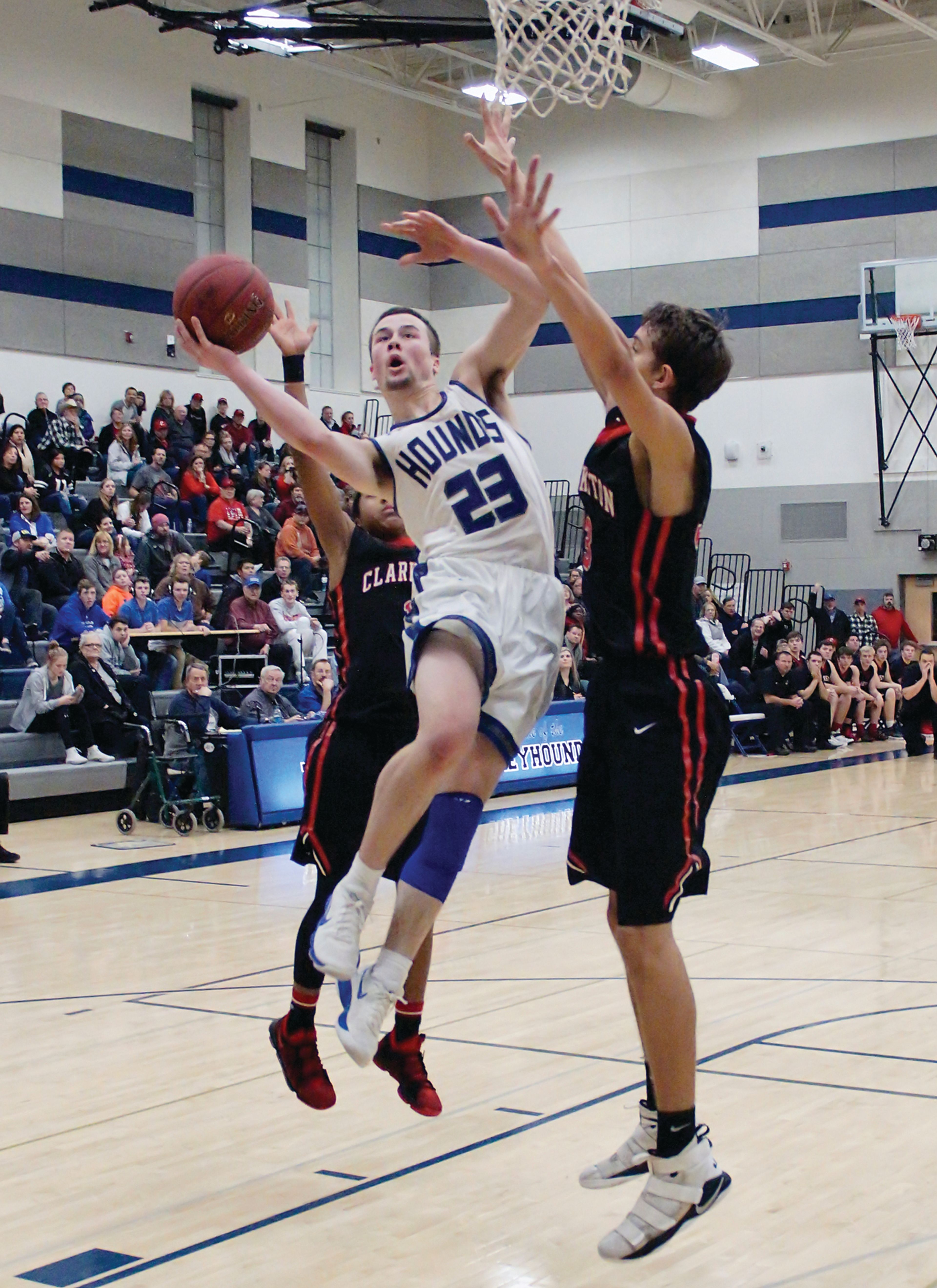 Pullman's Jake Wells (23) splits Clarkston defenders Tru Allen, left, and Brandton Chatfield for a shot Friday night in Pullman.