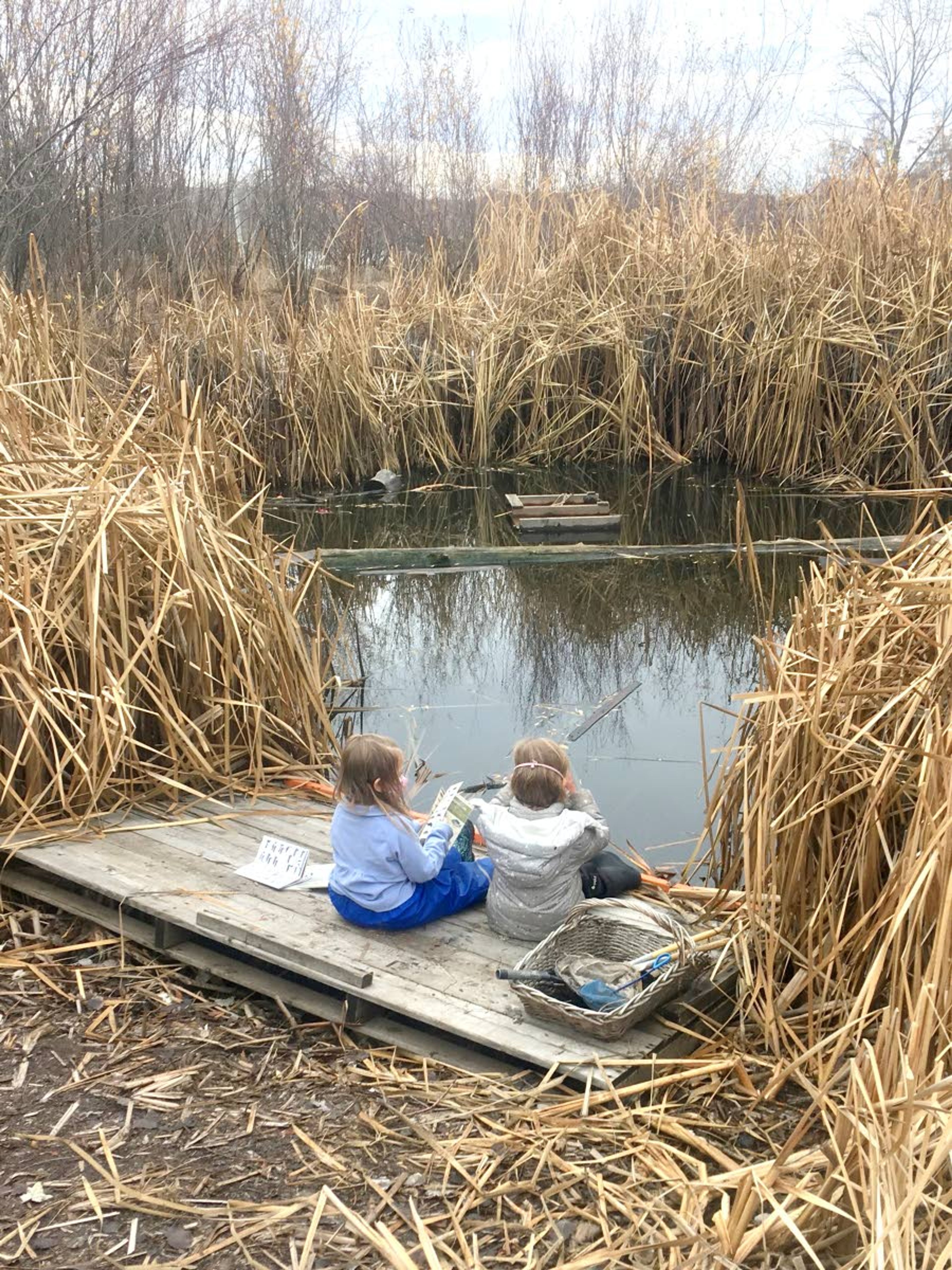 A pair of 4-year-old girls with binoculars and local animal identification books observe their surroundings as part of the Palouse Roots, an outdoor program through the Palouse-Clearwater Environmental Institute in Moscow.